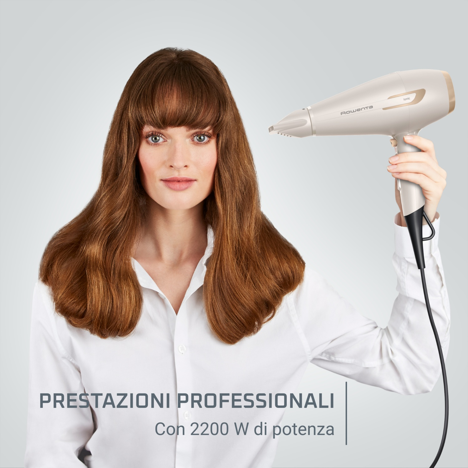 Una donna che tiene un asciugacapelli con una camicia bianca, con testo in basso.