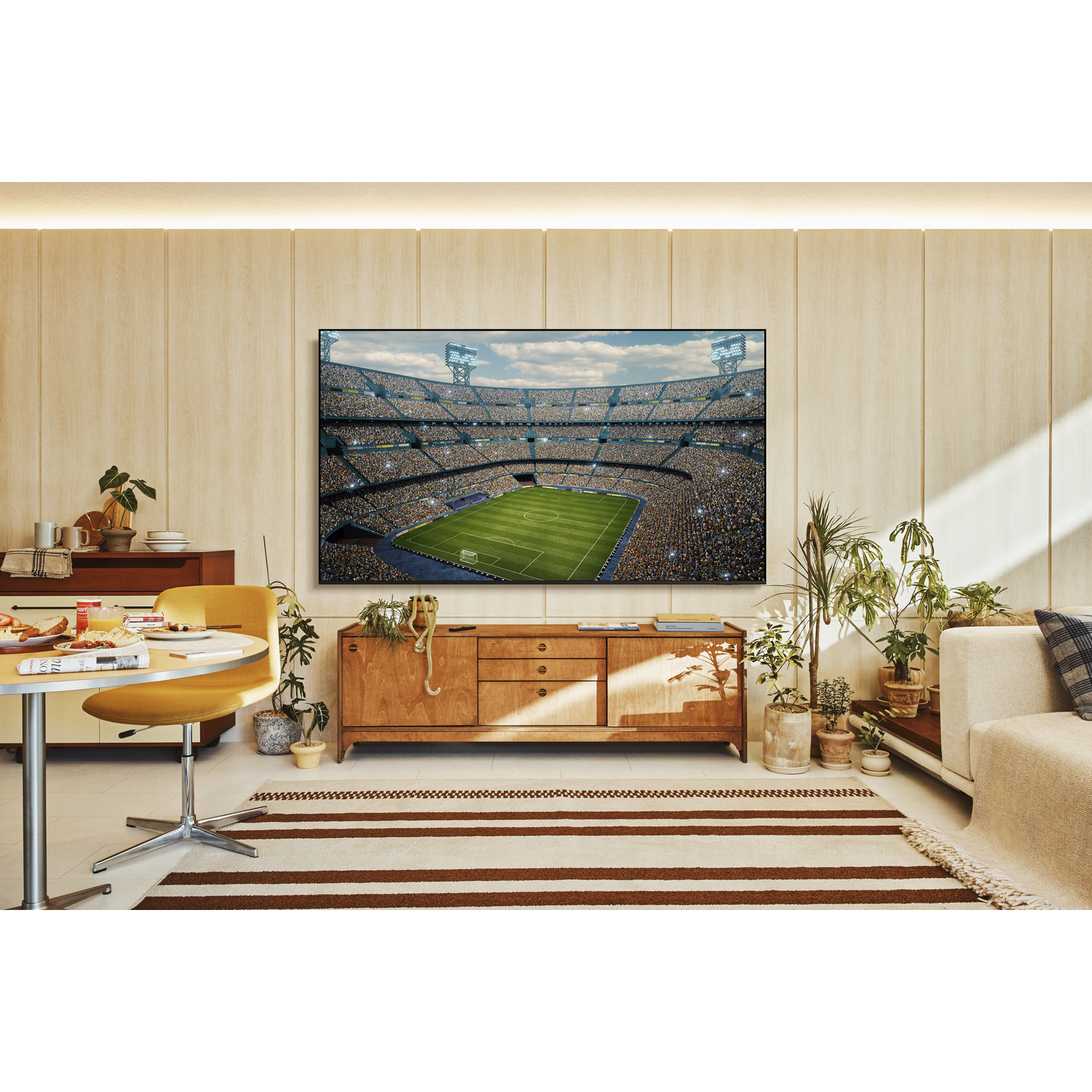 Een stel zit op een bank en kijkt naar een voetbalwedstrijd op tv.