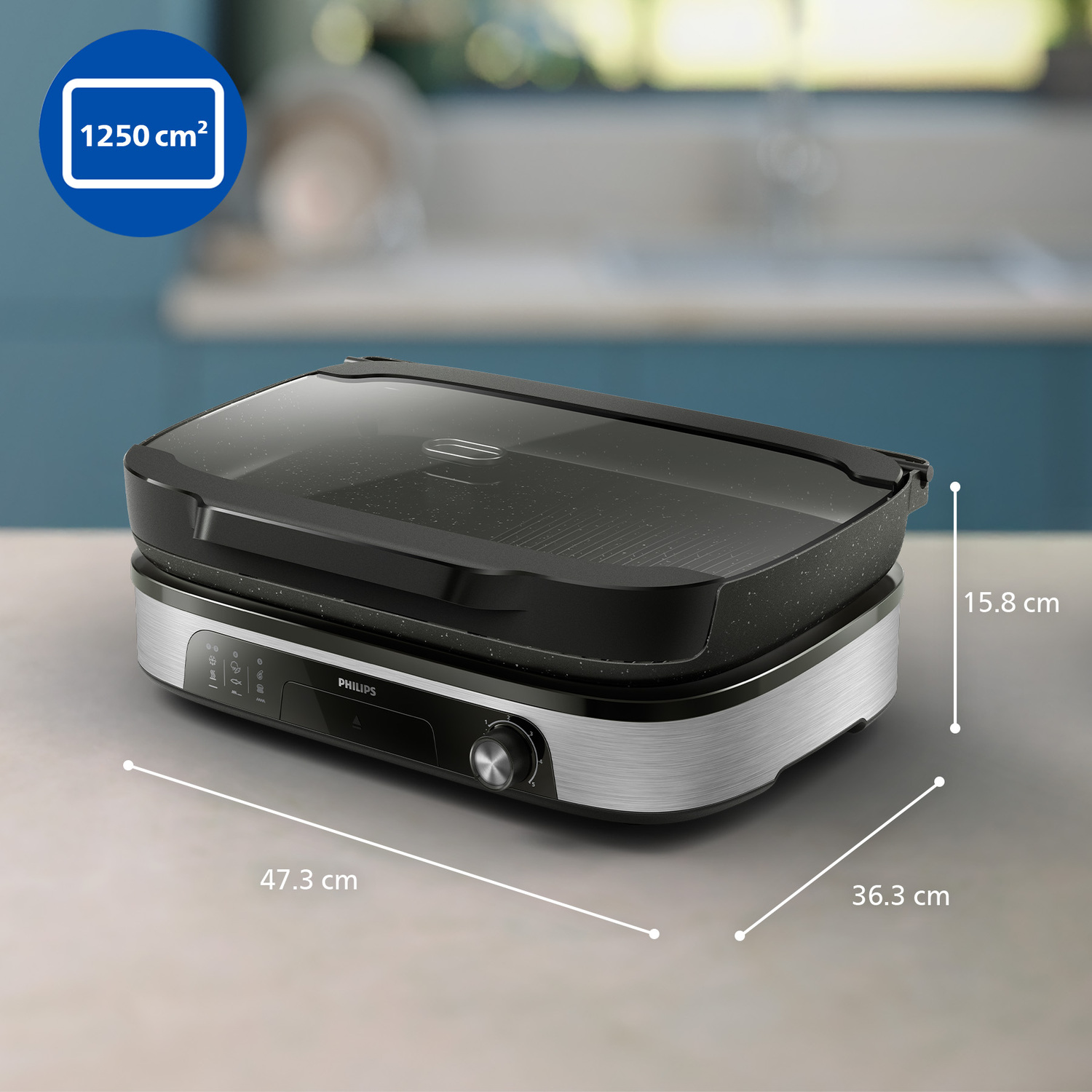 Un grill électrique Philips sur une table. Dimensions : 47,3 cm x 36,3 cm x 15,8 cm. Surface noire et base argentée.