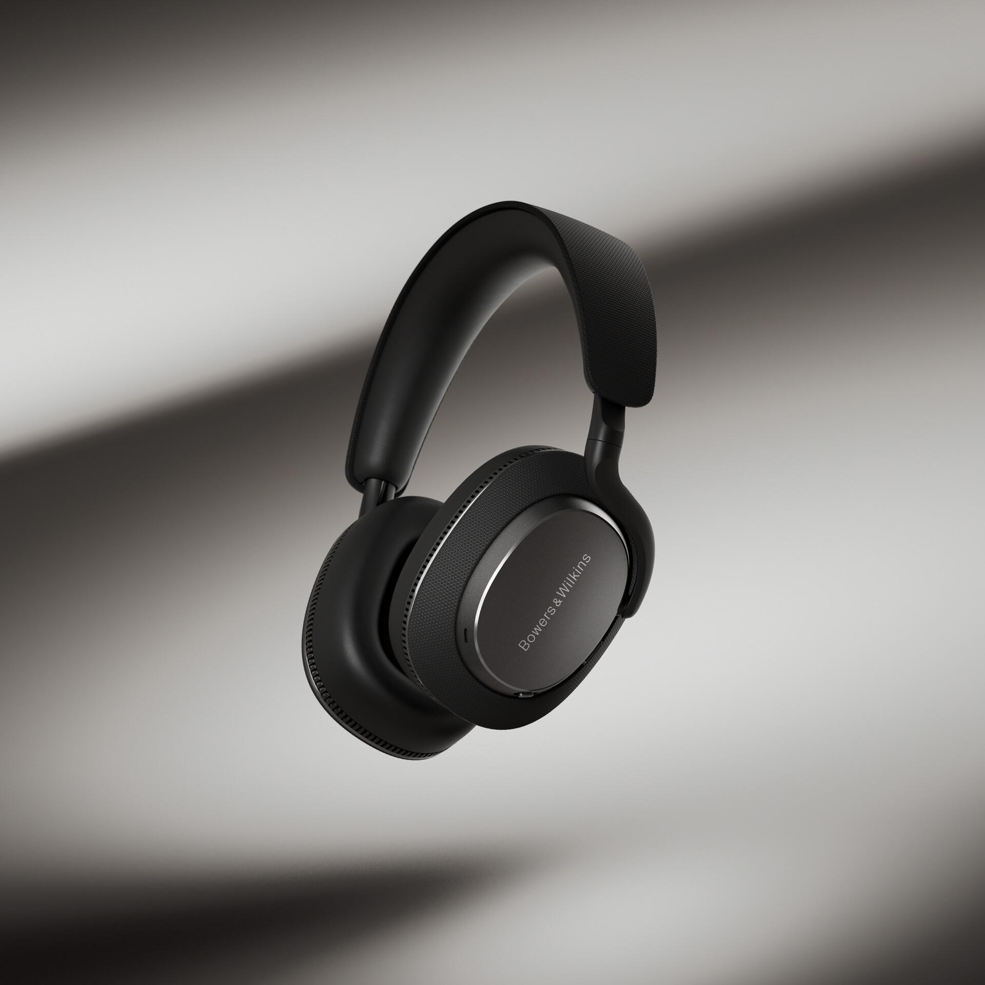 Schwarze Kopfhörer mit Bowers & Wilkins Logo, schweben in der Luft, grauer Hintergrund.