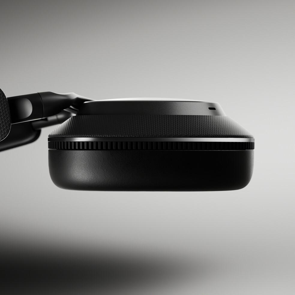 Schwarzes Headset, Seitenansicht. Der Ohrmuschel ist glatt, mit einem strukturierten Band.