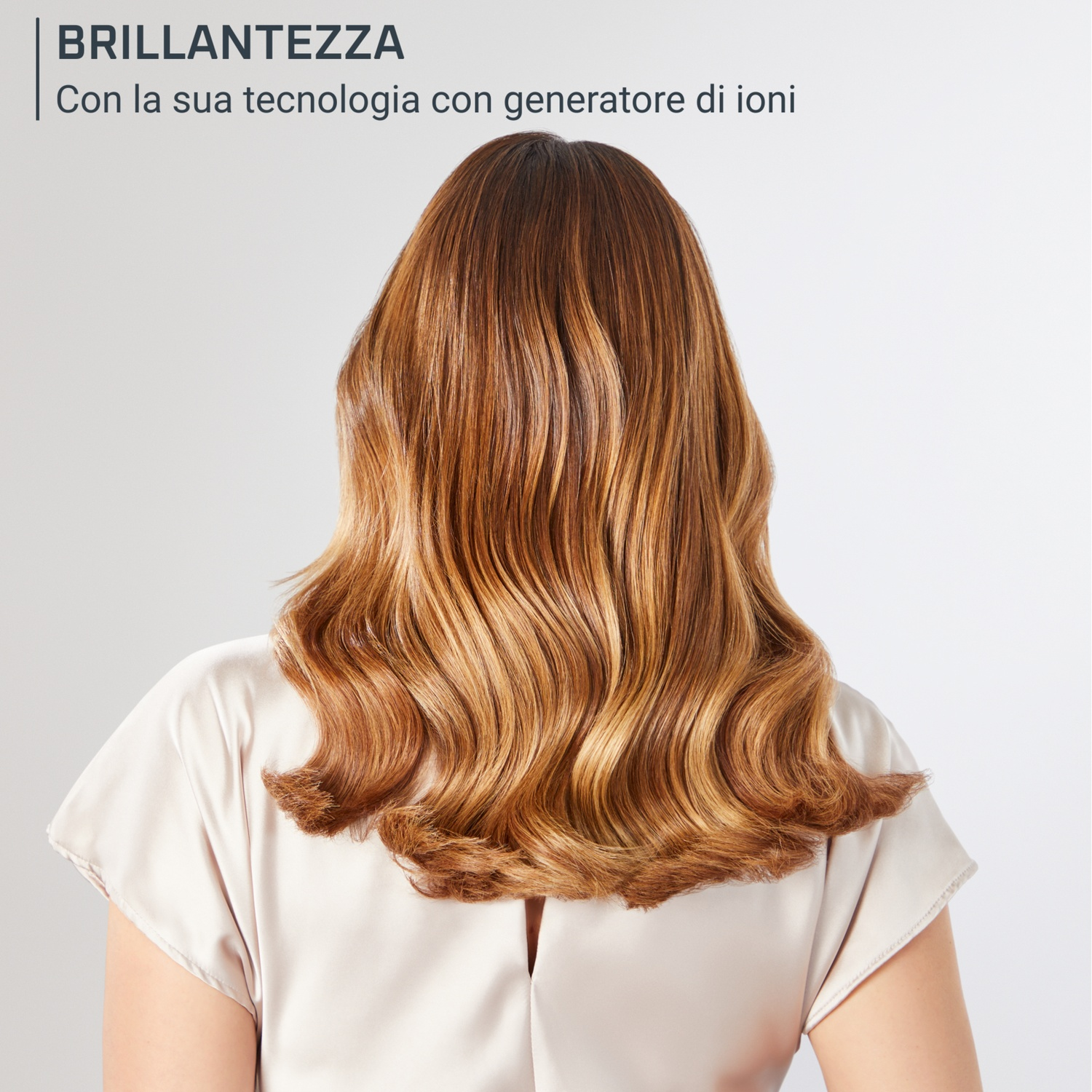 Donna con capelli lucenti. Il testo recita: Brillantezza, con tecnologia a generatore di ioni.