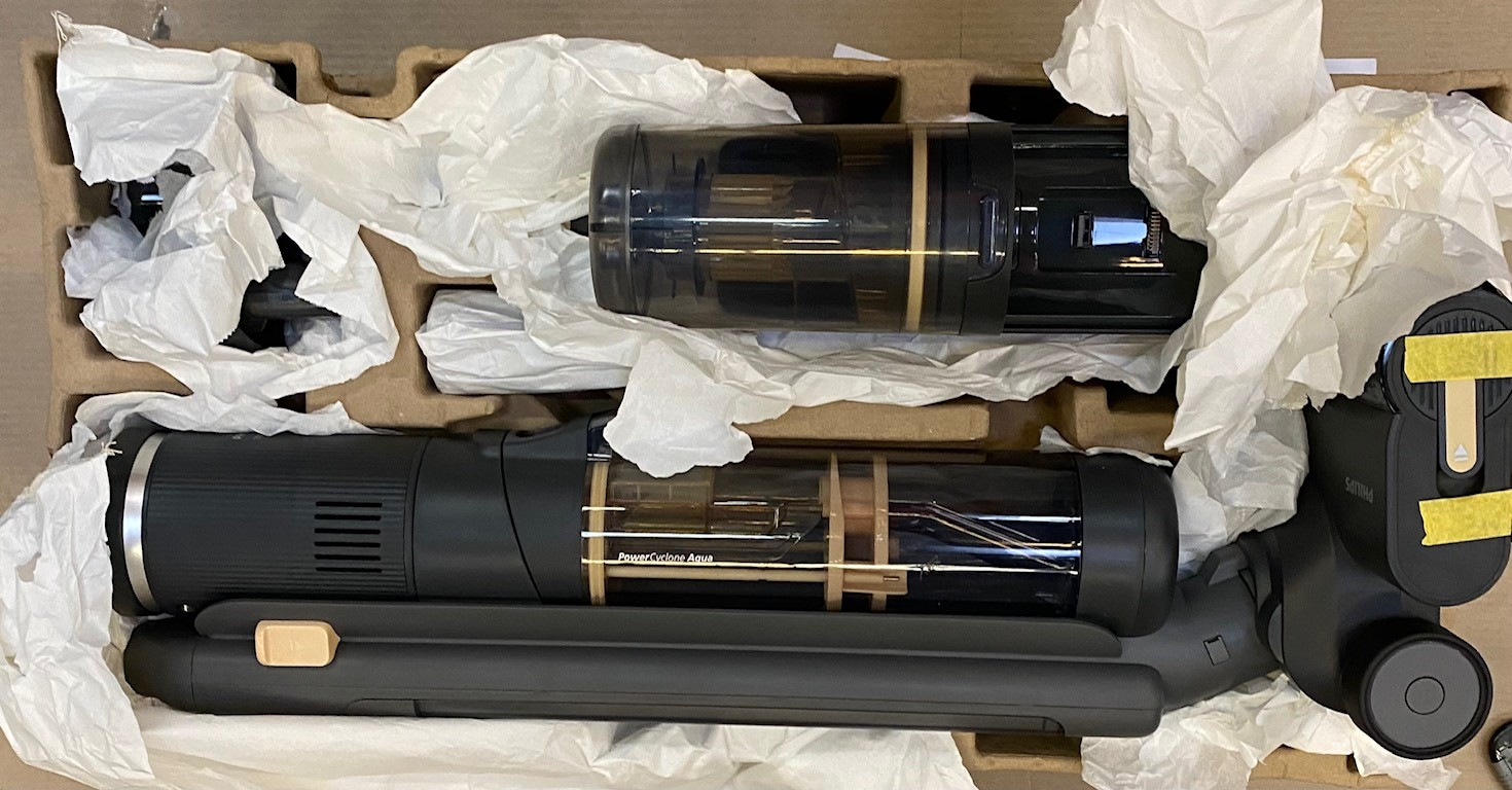 Dwa czarne rury odkurzacza z przezroczystymi pojemnikami w kartonowym pudełku.