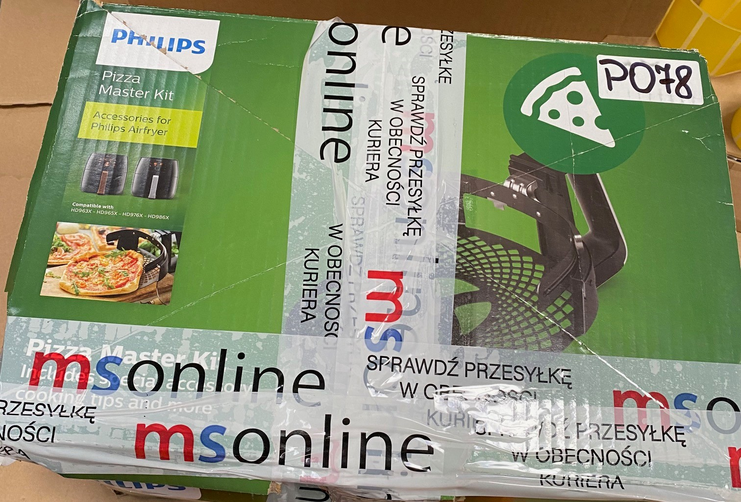 Pudełko Philips Pizza Master Kit z taśmą wysyłkową i grafiką kawałka pizzy.