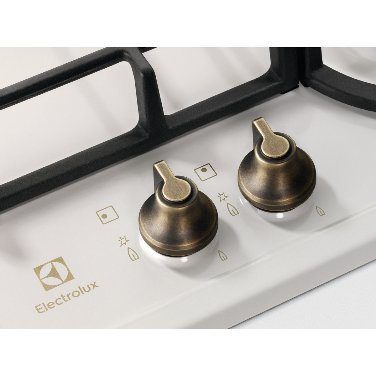 İki pirinç düğmeli ve siyah ızgaralı bir ocak üstünün yakın çekimi. Electrolux logosu görünür.