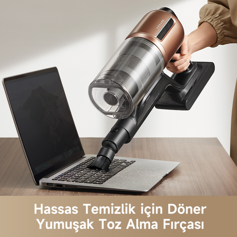 Bir el, bir dizüstü bilgisayarın üzerinde bir elektrik süpürgesi tutuyor. Elektrik süpürgesinin klavyeyi temizleyen bir fırça başlığı var.