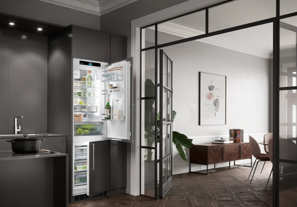 Küche mit offenem Kühlschrank, dunklen Schränken und Glastür.