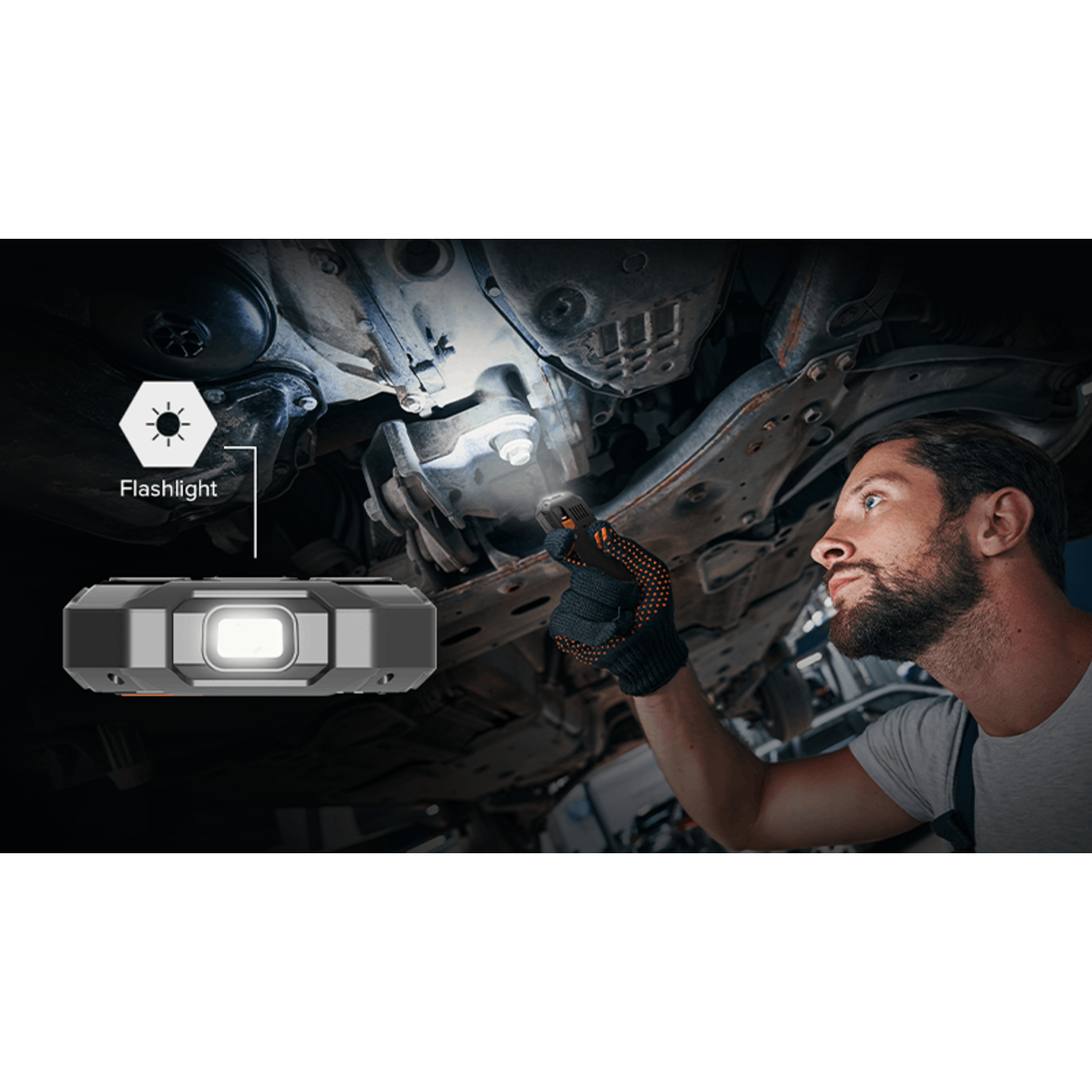 A mechanic uses a flashlight to inspect a car's underside. The scene is lit by the flashlight. The mechanic wears gloves and a work shirt.