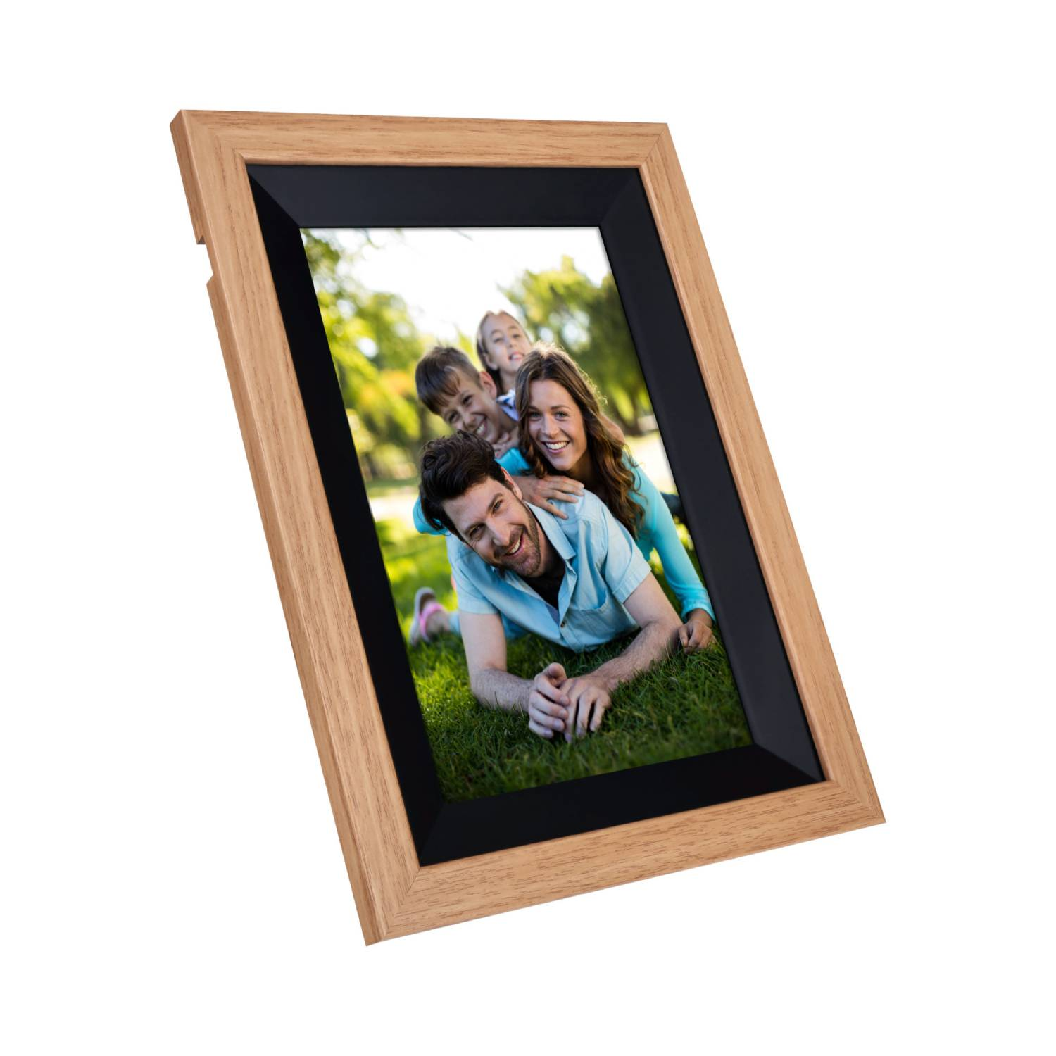 A wooden photo frame with a family photo inside. The family is smiling and lying on the grass.