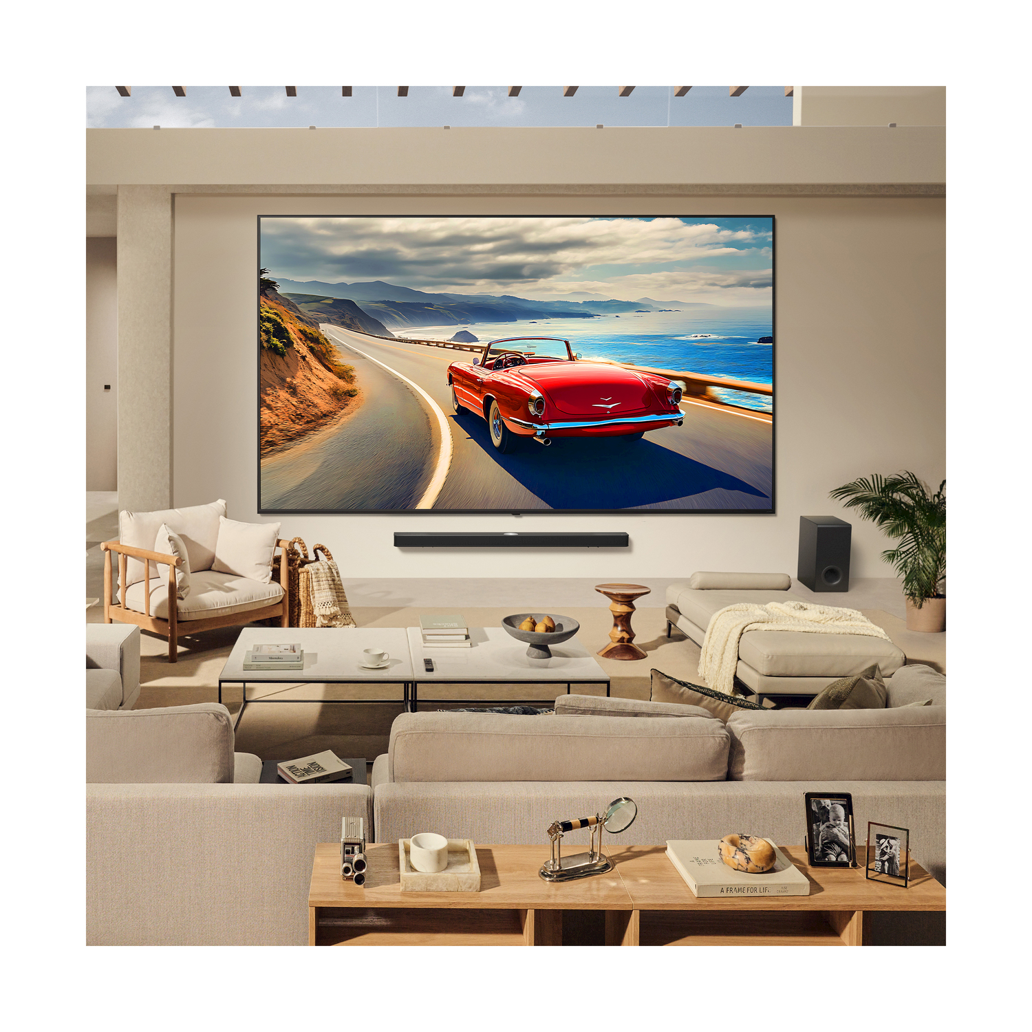 Soggiorno con grande TV che mostra un'auto rossa su una strada costiera. Sono presenti soundbar e subwoofer.