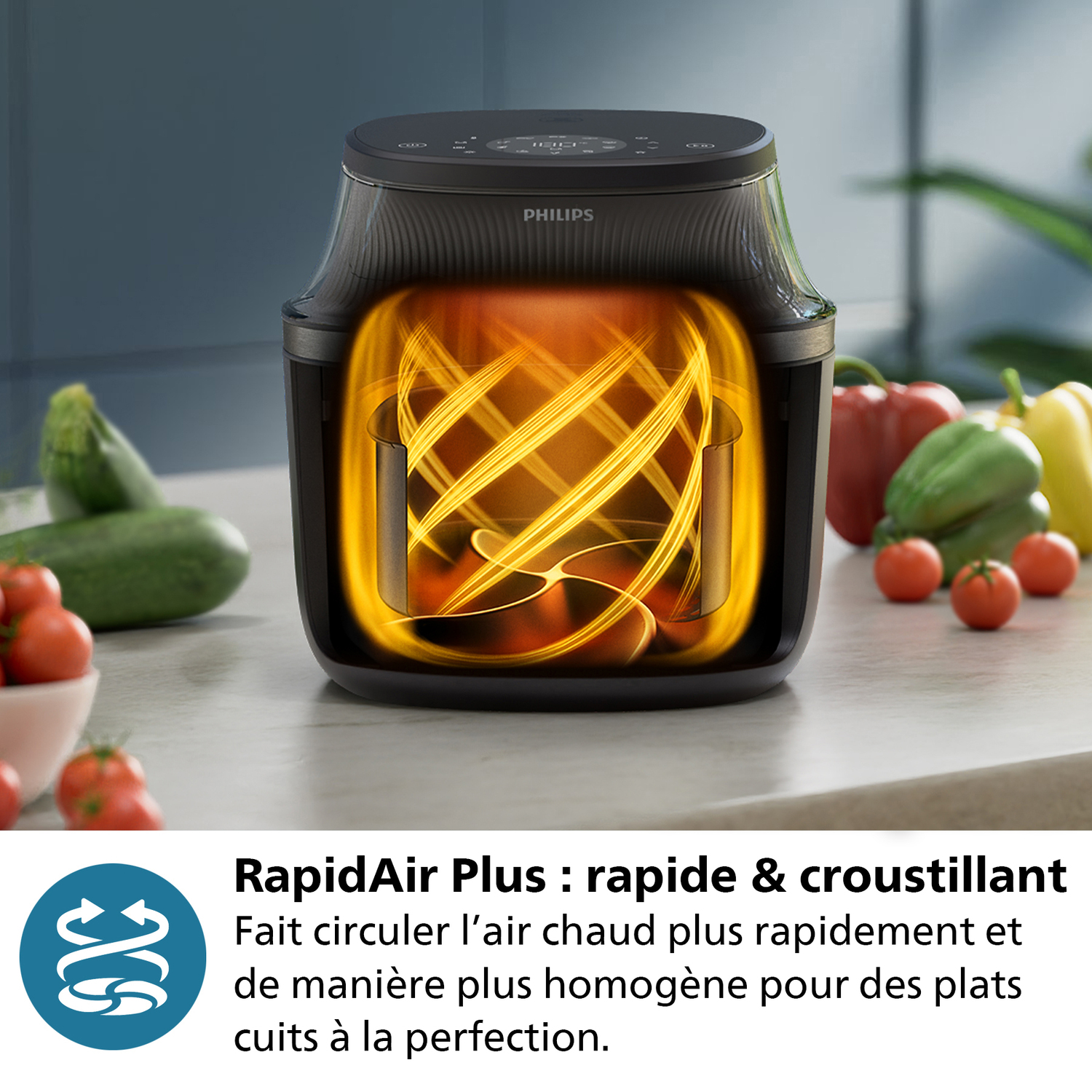 Friteuse à air avec tomates à l'intérieur, entourée de légumes.