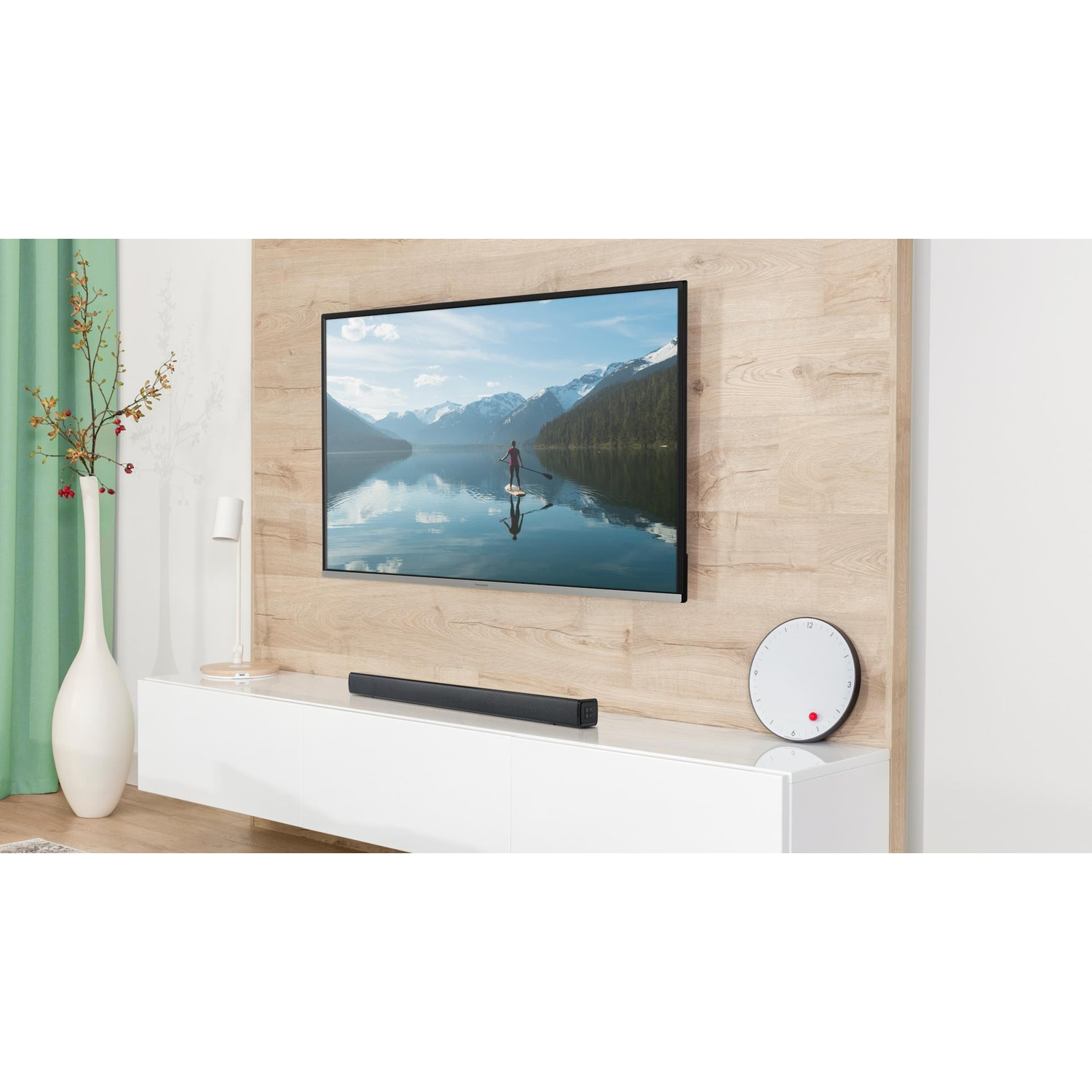 Una TV montata su una parete in legno chiaro con una soundbar sottostante.