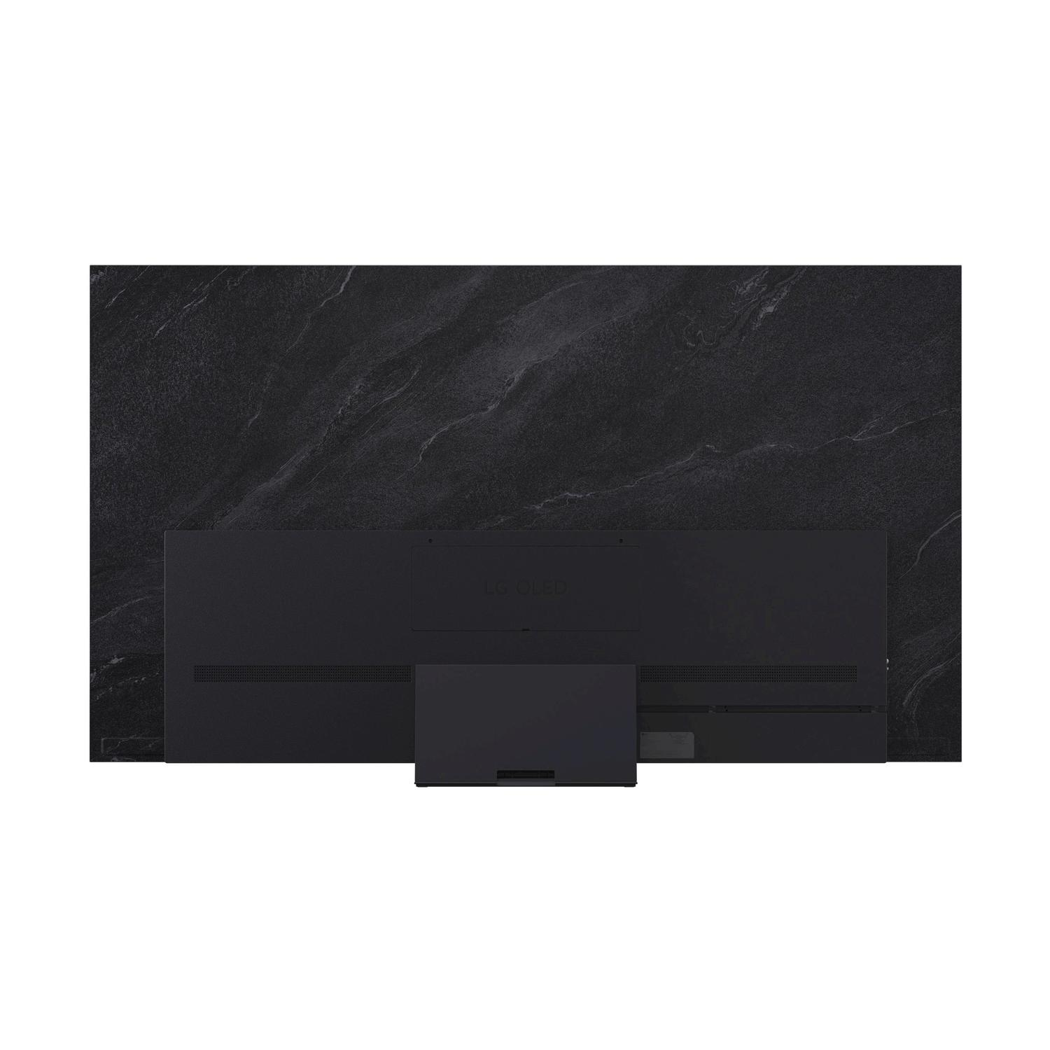 Vista posteriore di una TV nera, montata su una superficie nera effetto marmo.