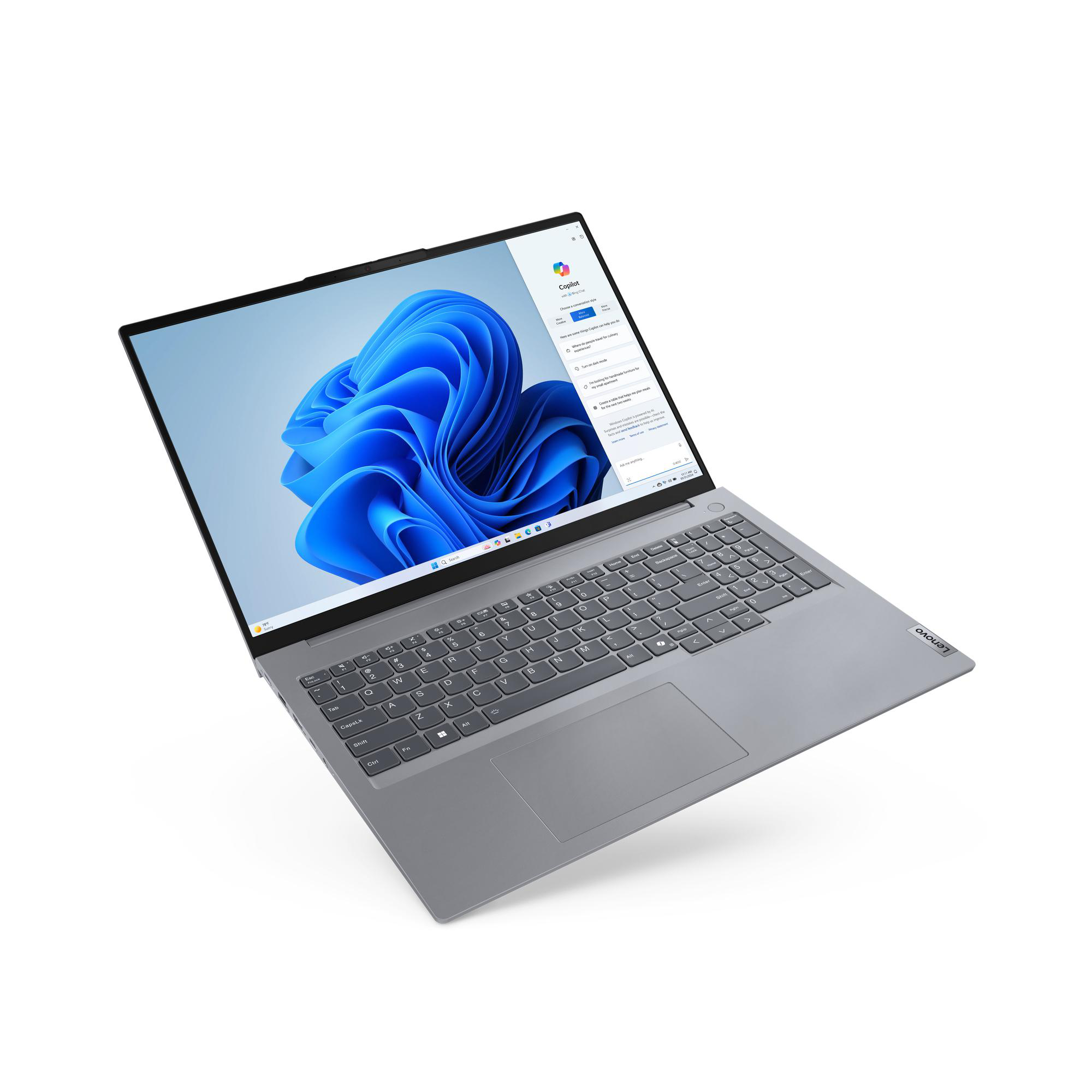 Ein silberner Laptop ist auf einer weißen Oberfläche geöffnet und zeigt einen Windows-Desktop mit blauem Hintergrund.
