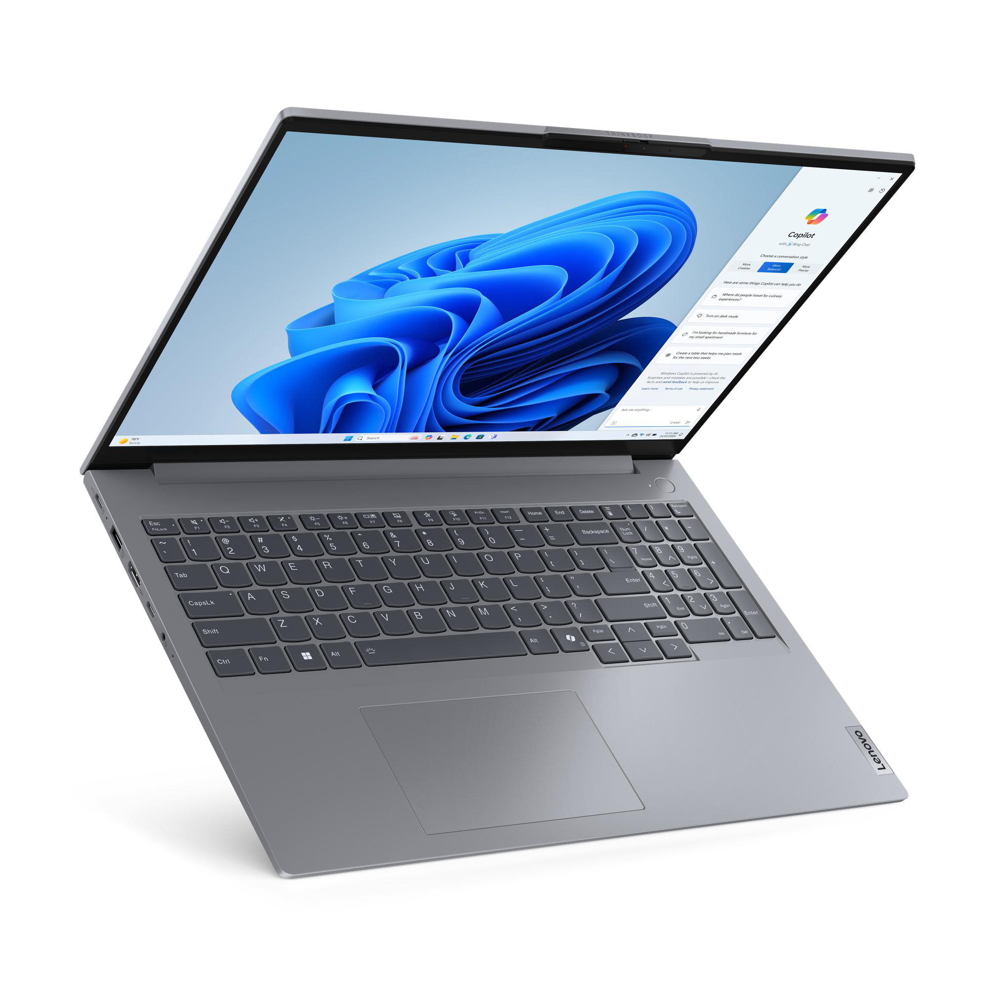 Silberner Laptop, geöffnet und angewinkelt auf Weiß, zeigt Windows-Oberfläche und Lenovo-Logo.