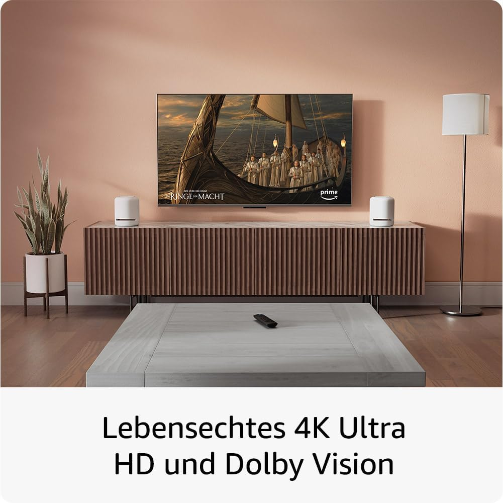 Ein Fernseher, der eine Szene aus einer Sendung zeigt, mit Lautsprechern und einem Couchtisch.