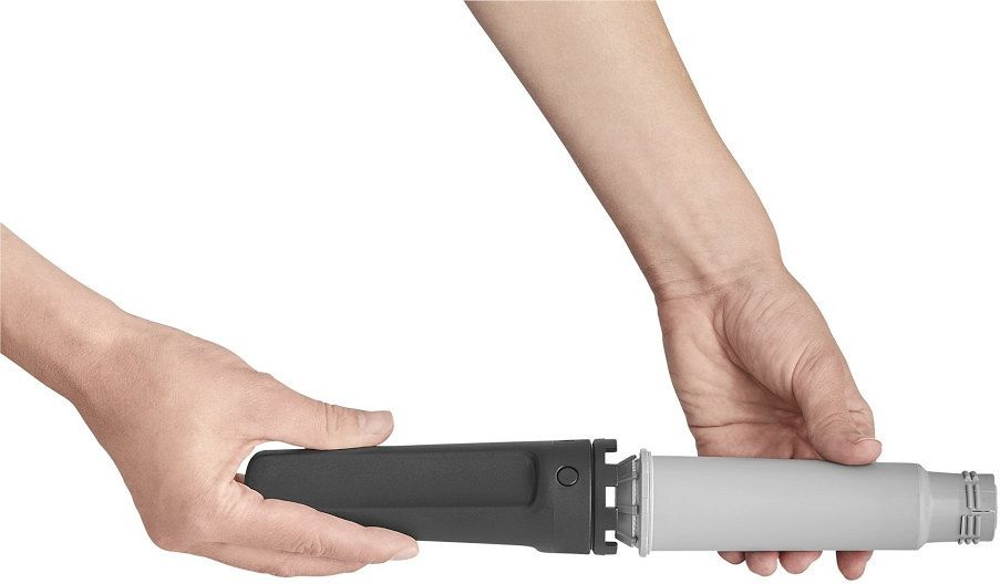 Ręce składające czarny uchwyt do szarej rury.