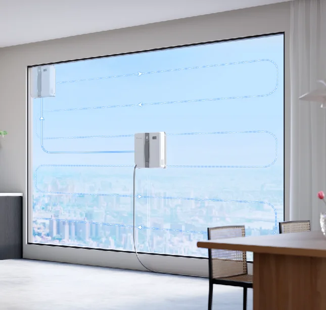 Robot do czyszczenia okien jest przymocowany do okna i porusza się po wzorze, na zewnątrz widok na miasto.