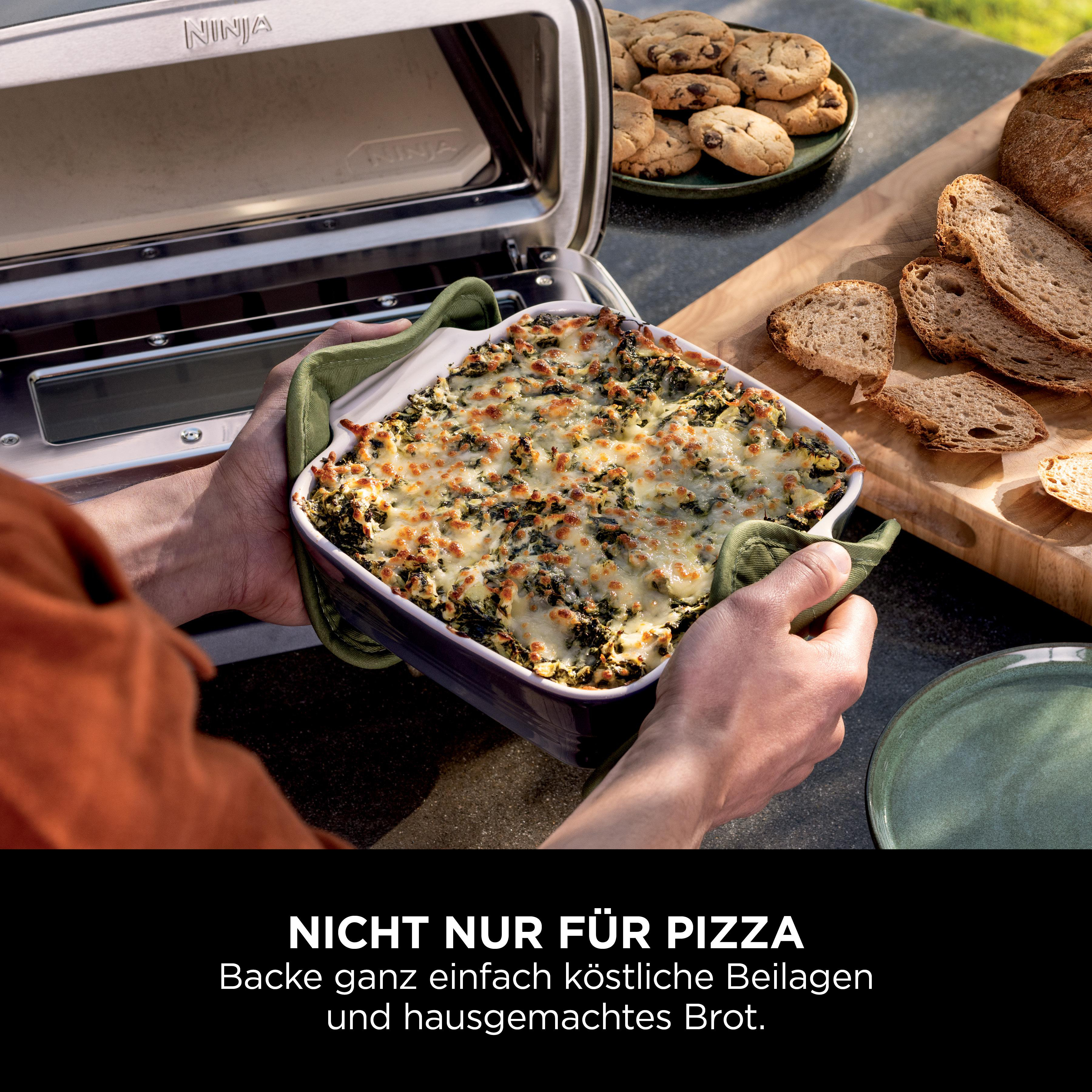 Eine Person hält ein Backgericht. Das Gericht enthält eine grüne Füllung. Der Ofen ist im Hintergrund.
