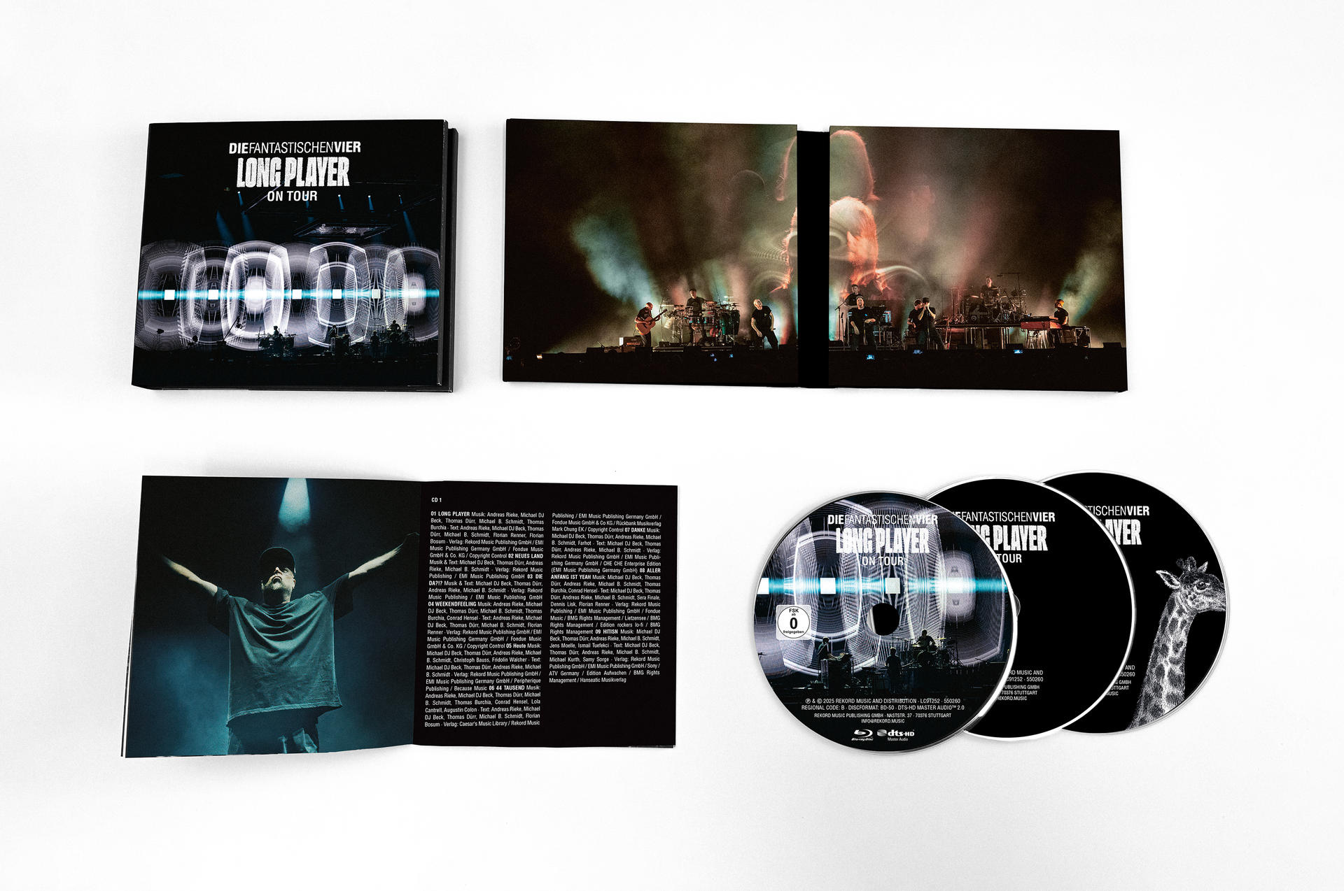 Albumcover: Schwarzes Album mit weißem Logo, CDs und geöffnetem Booklet auf weißer Oberfläche.