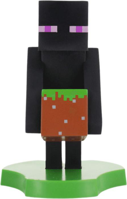 Ein Minecraft Enderman Spielzeug, das einen Erdblock auf einer grünen Plattform hält.
