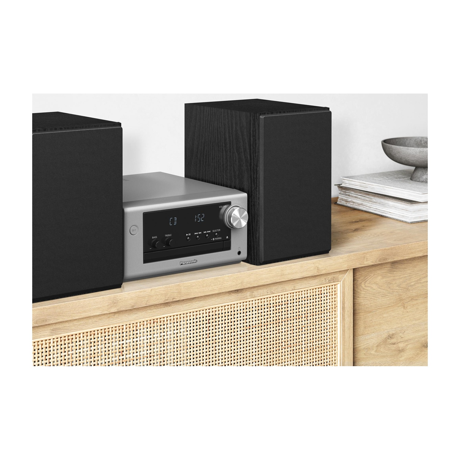 Un sistema stereo. Un ricevitore argentato è tra due altoparlanti neri su una mensola di legno.