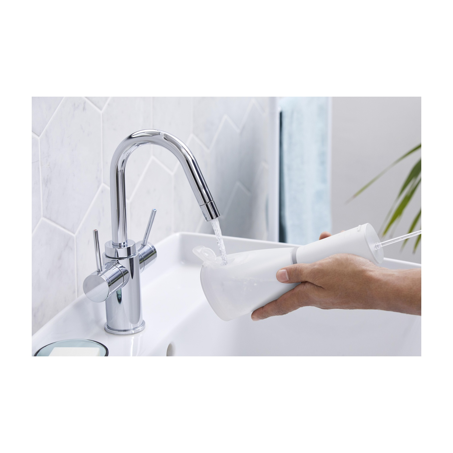 Persona che riempie un contenitore con acqua da un rubinetto.