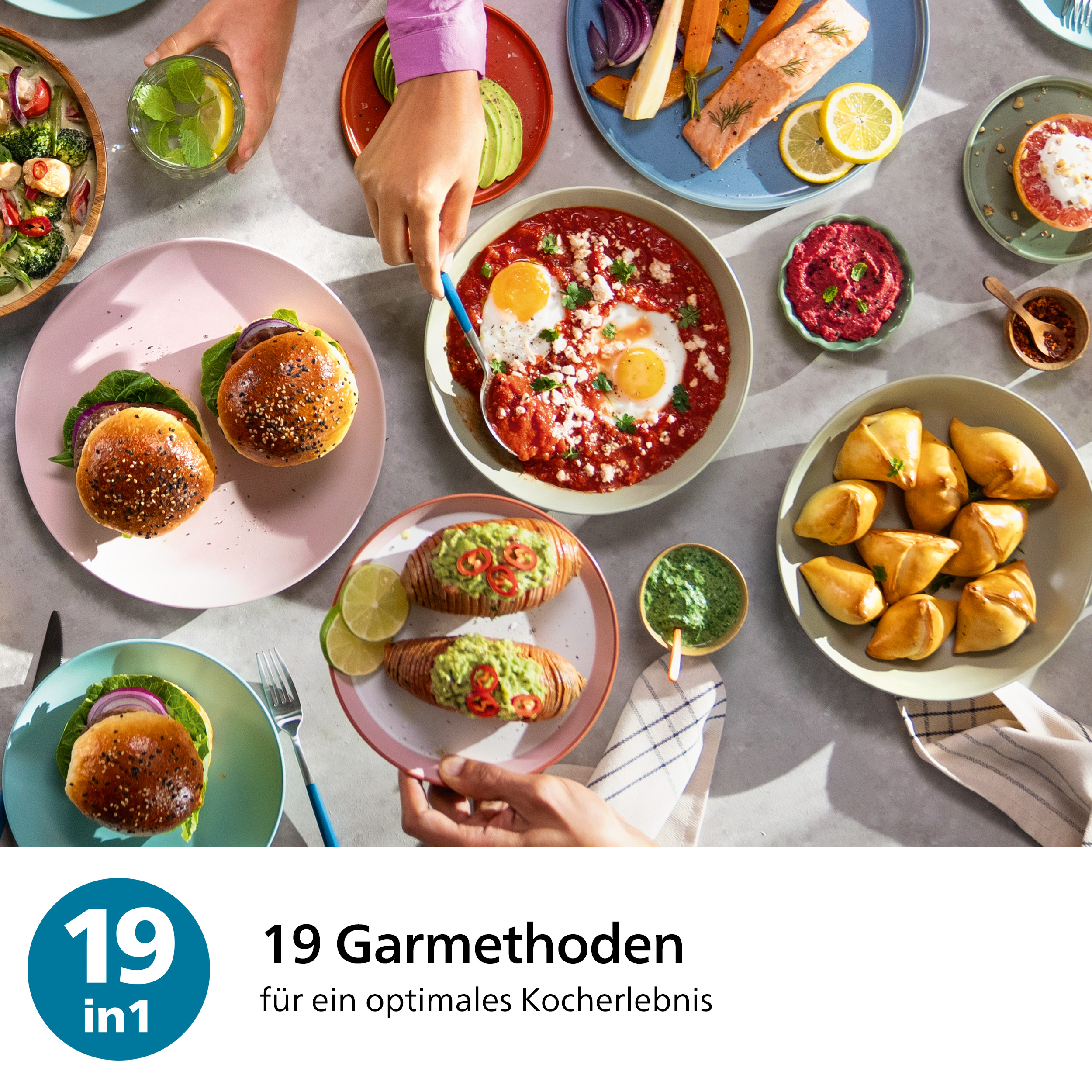 Draufsicht auf Teller mit Burgern, Eiern, Avocado und anderen bunten Gerichten. Hände drum herum.