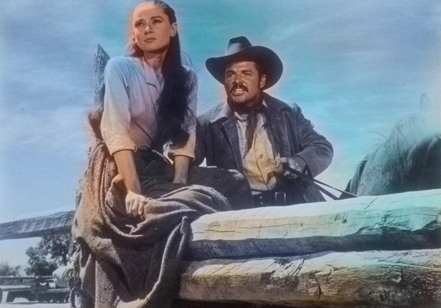 Eine Frau und ein Mann in Westernkleidung sitzen auf einem Holzgefährt.