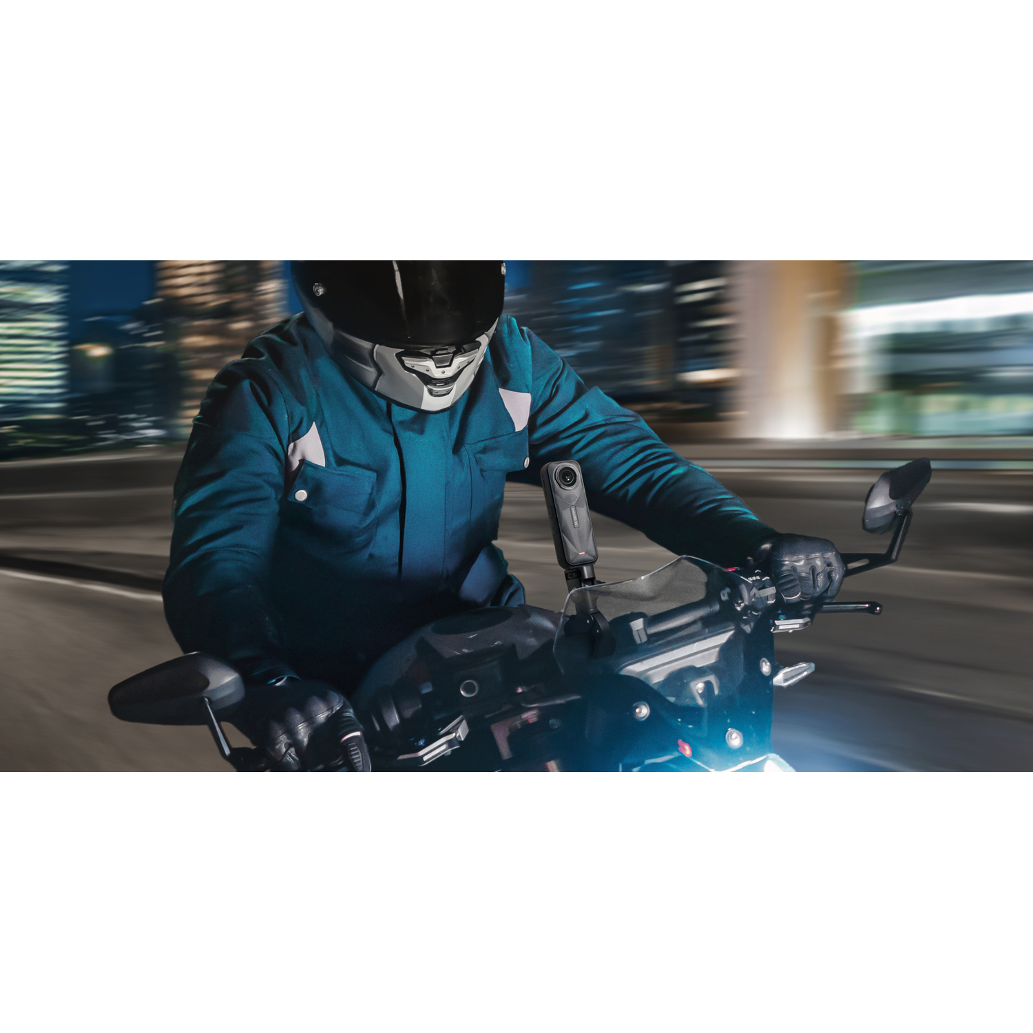 Une personne fait de la moto la nuit, portant un casque et une veste. Une caméra est attachée.