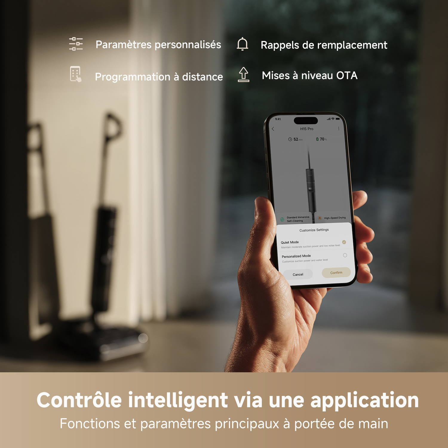 Une main tenant un téléphone affichant une application domotique avec des aspirateurs.