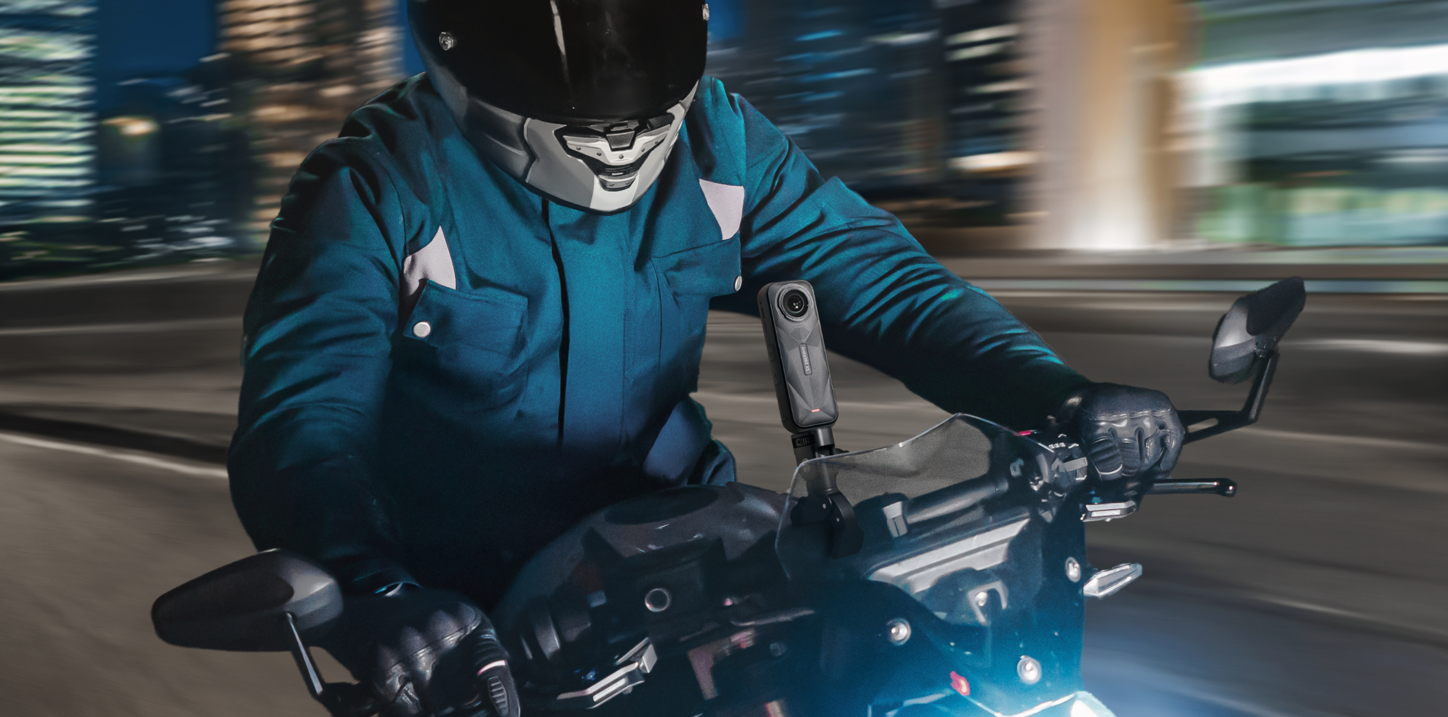 Une personne sur une moto portant un casque et une caméra fixée sur la moto.