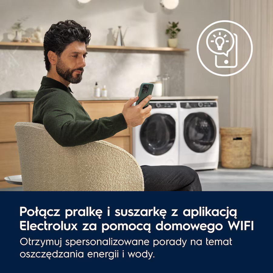 Mężczyzna w zieleni trzymający telefon, siedzący obok pralki/suszarki Electrolux. Ikona z żarówką.