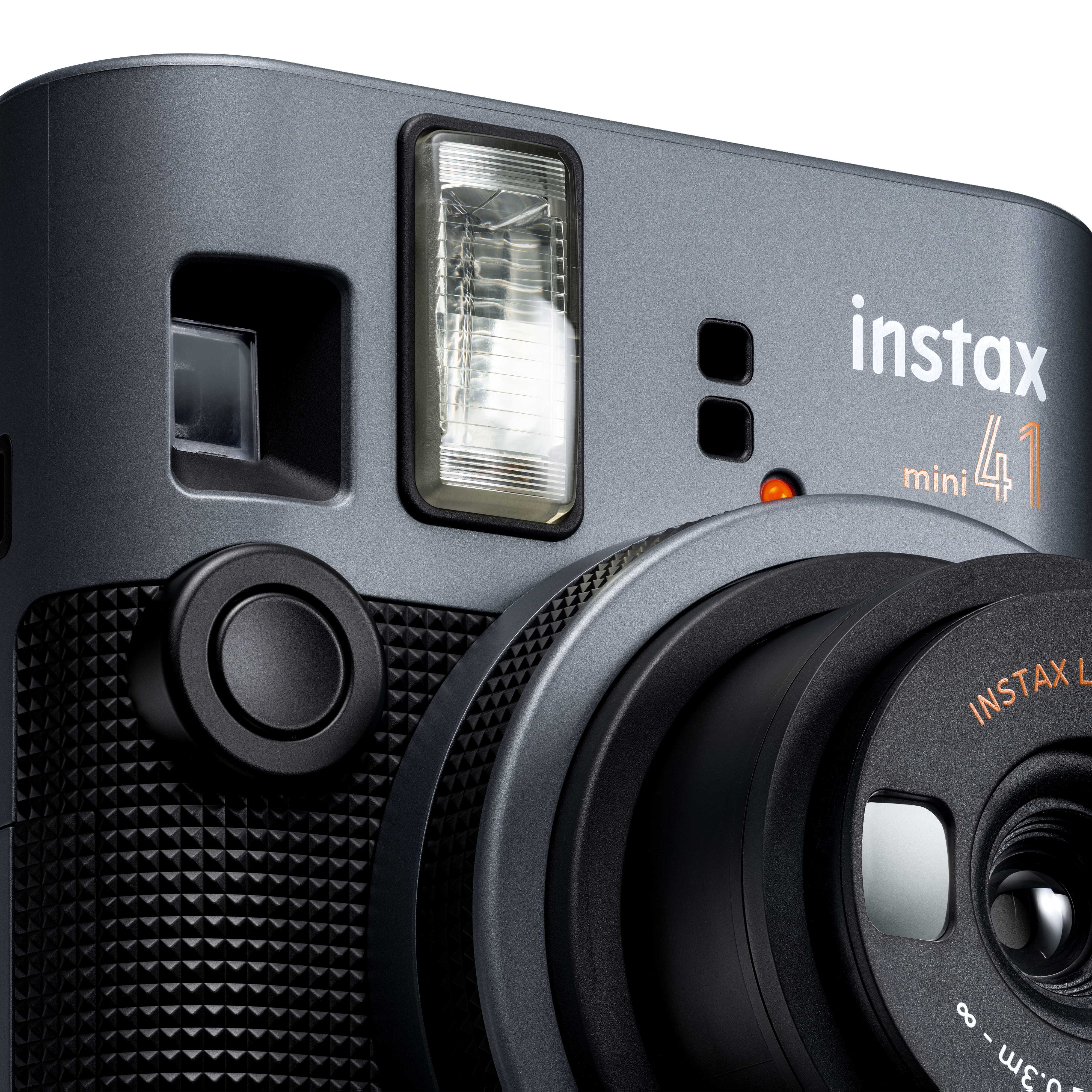 Nahaufnahme einer grauen Instax Mini 41 Kamera. Sie hat einen Blitz und ein Objektiv.