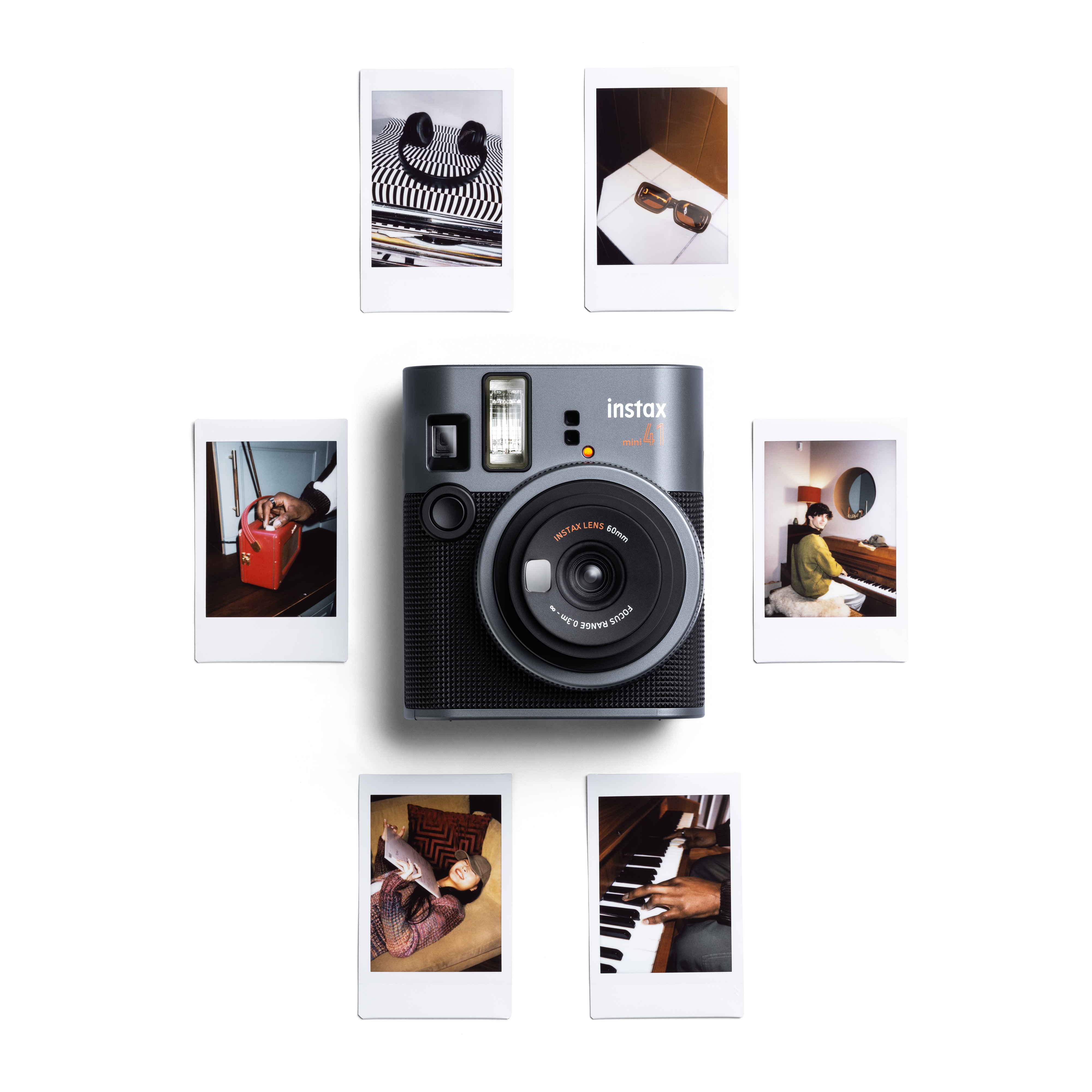 Graue Instax Mini Kamera, umgeben von Fotos. Fotos zeigen verschiedene Szenen und Personen.