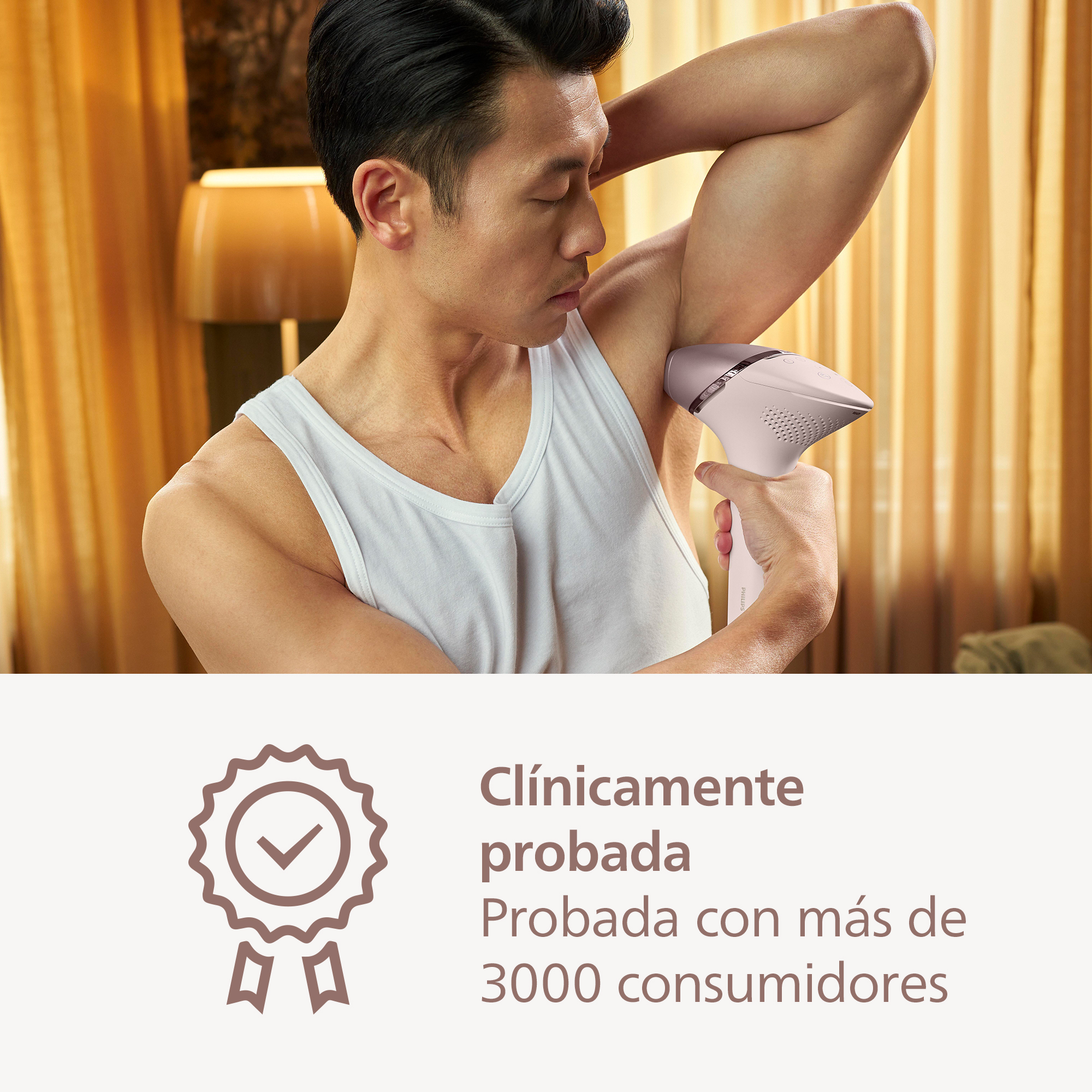 Un hombre se afeita la axila con un dispositivo rosa de depilación. Una luz es visible.