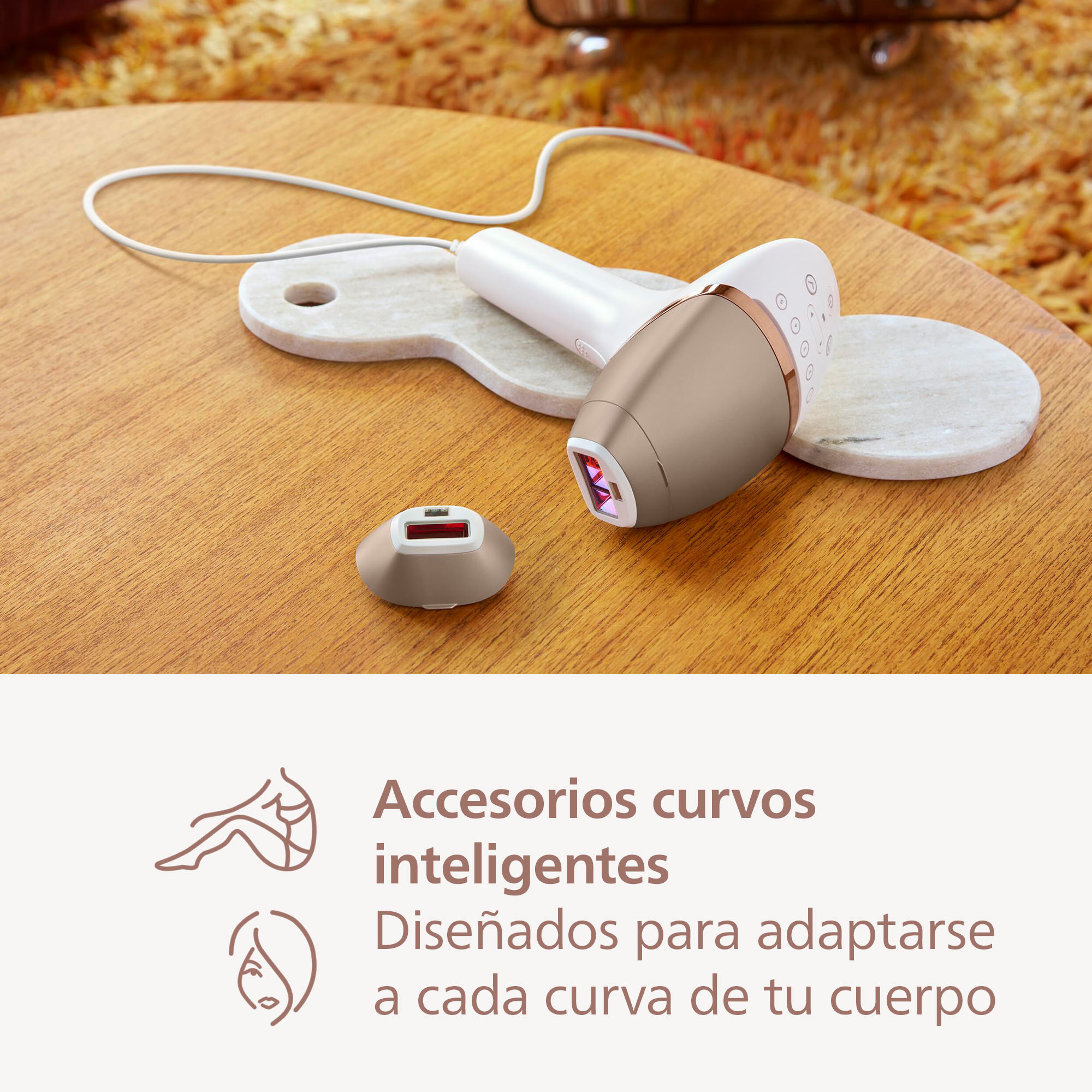 Un dispositivo de depilación Philips dorado y blanco con accesorios.