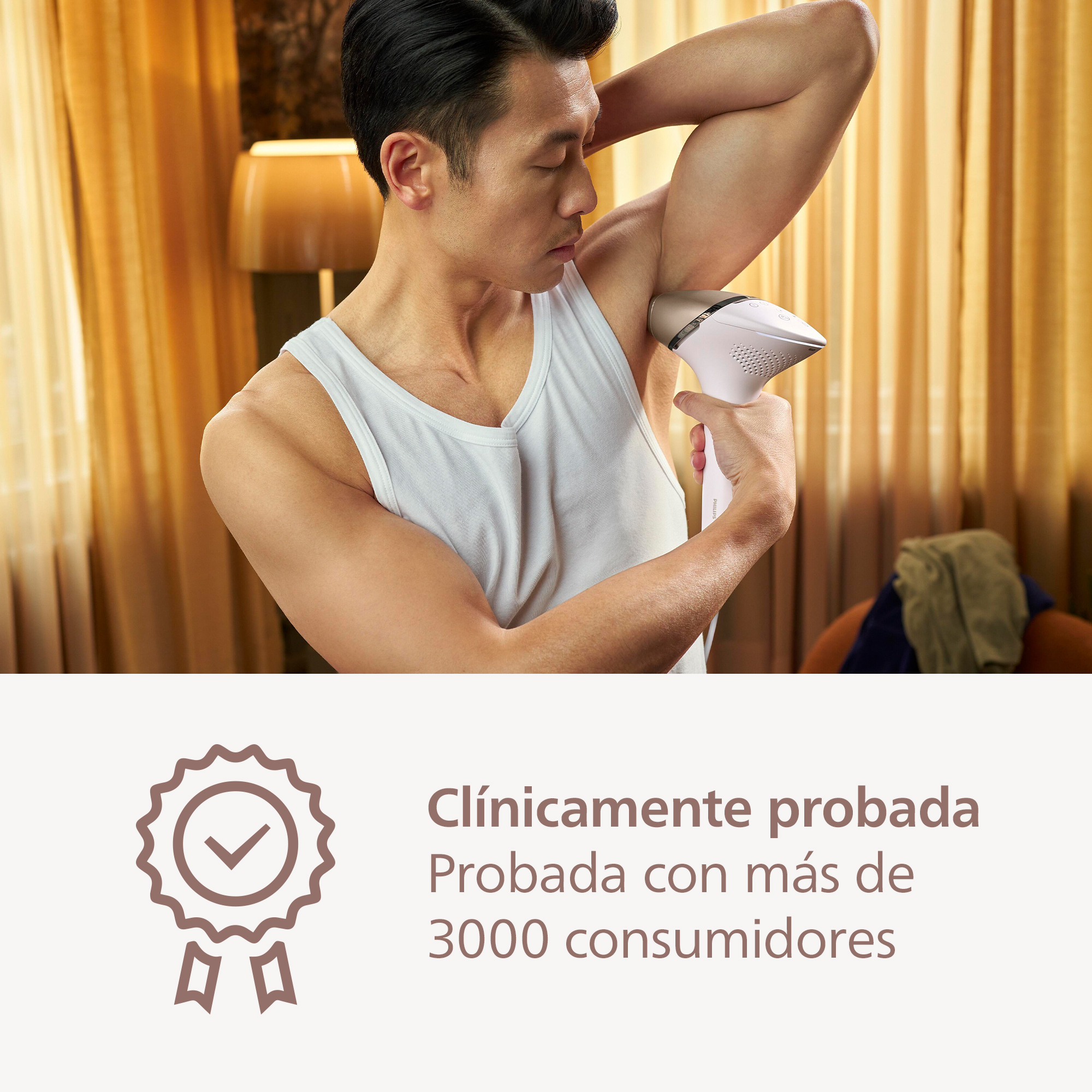 Un hombre usa un dispositivo blanco de depilación en su axila en una habitación bien iluminada.