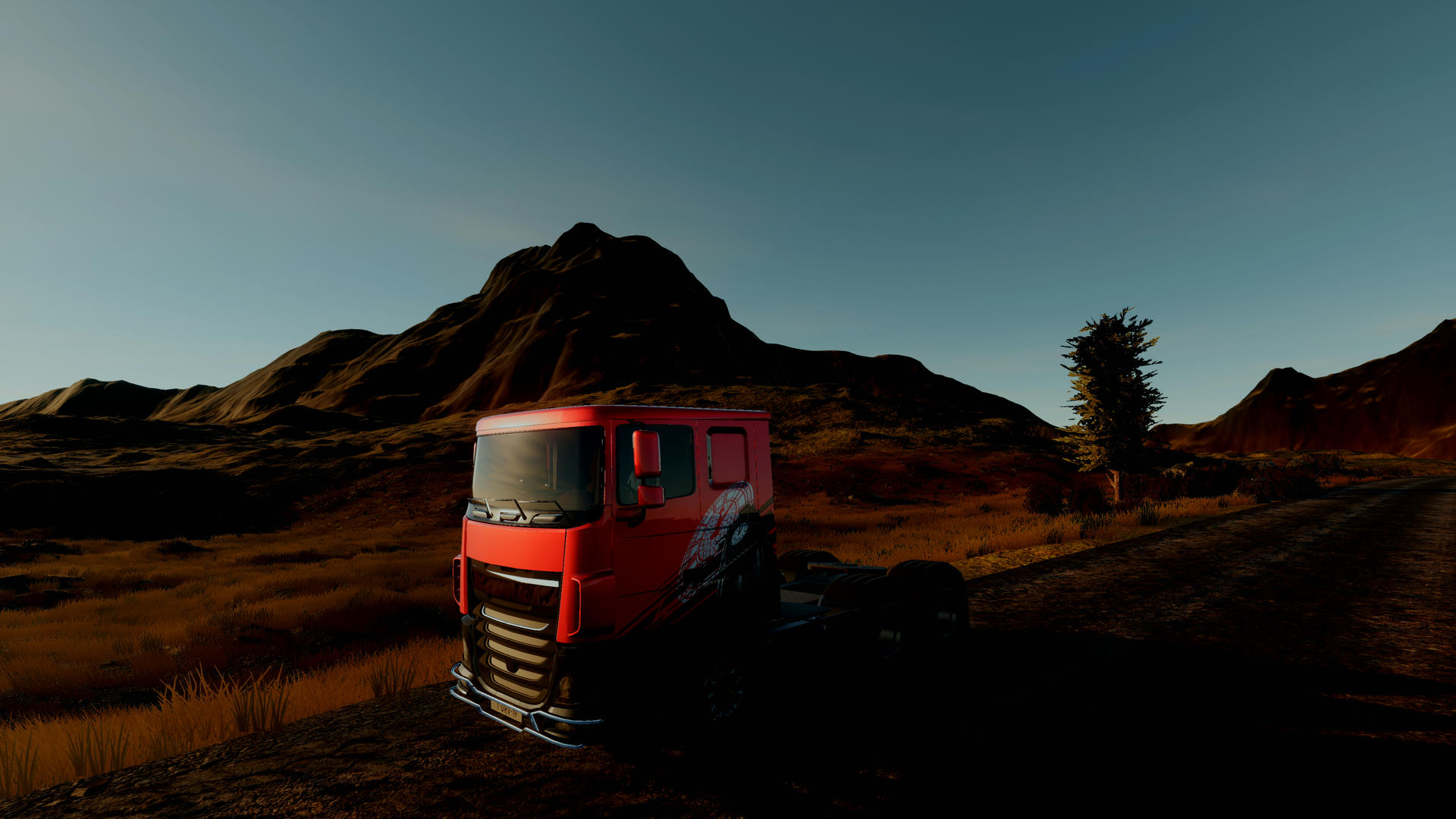 Ein roter LKW steht auf einer Schotterstraße vor braunen Hügeln unter blauem Himmel.