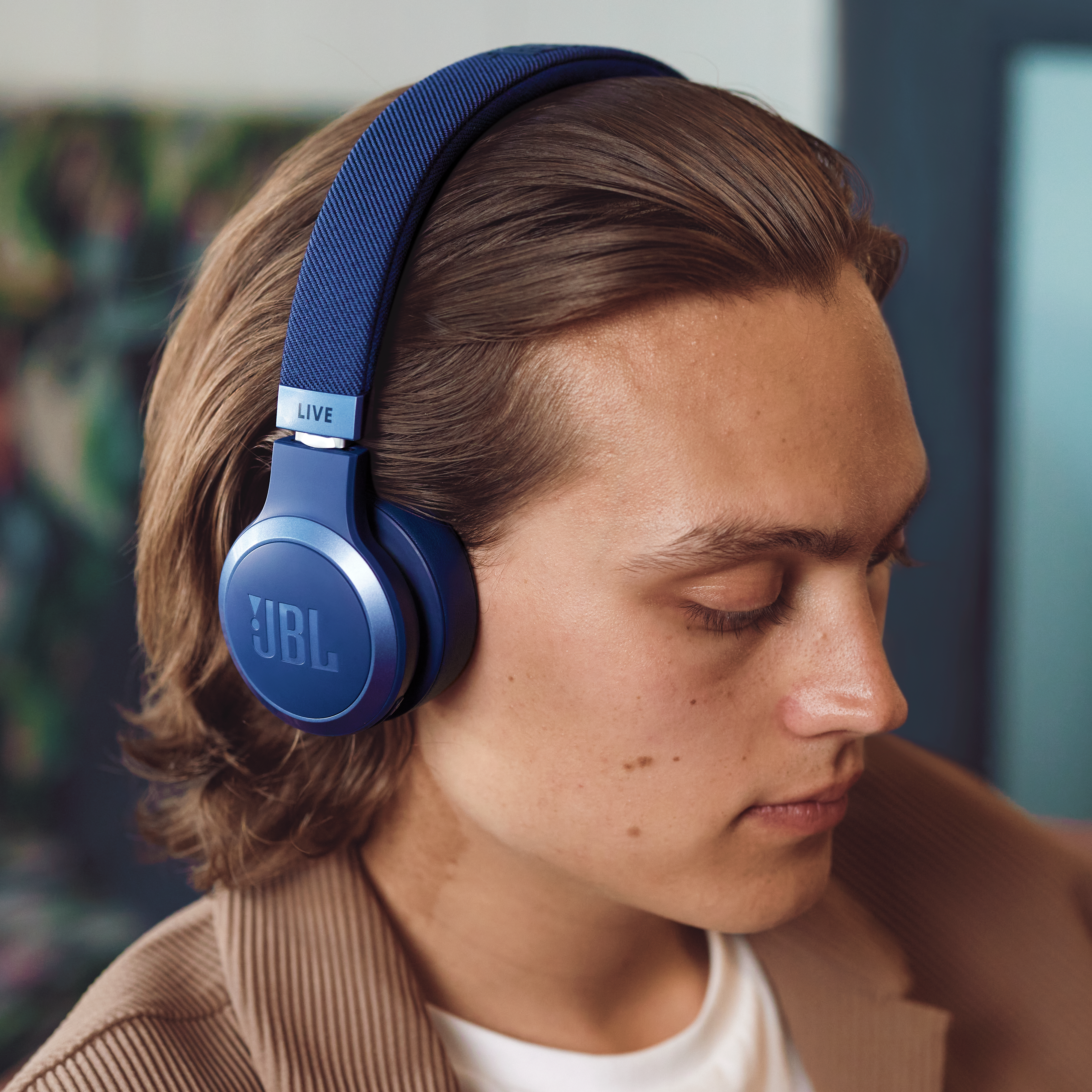 Homme portant un casque bleu. Le casque est sur sa tête. Veste marron.
