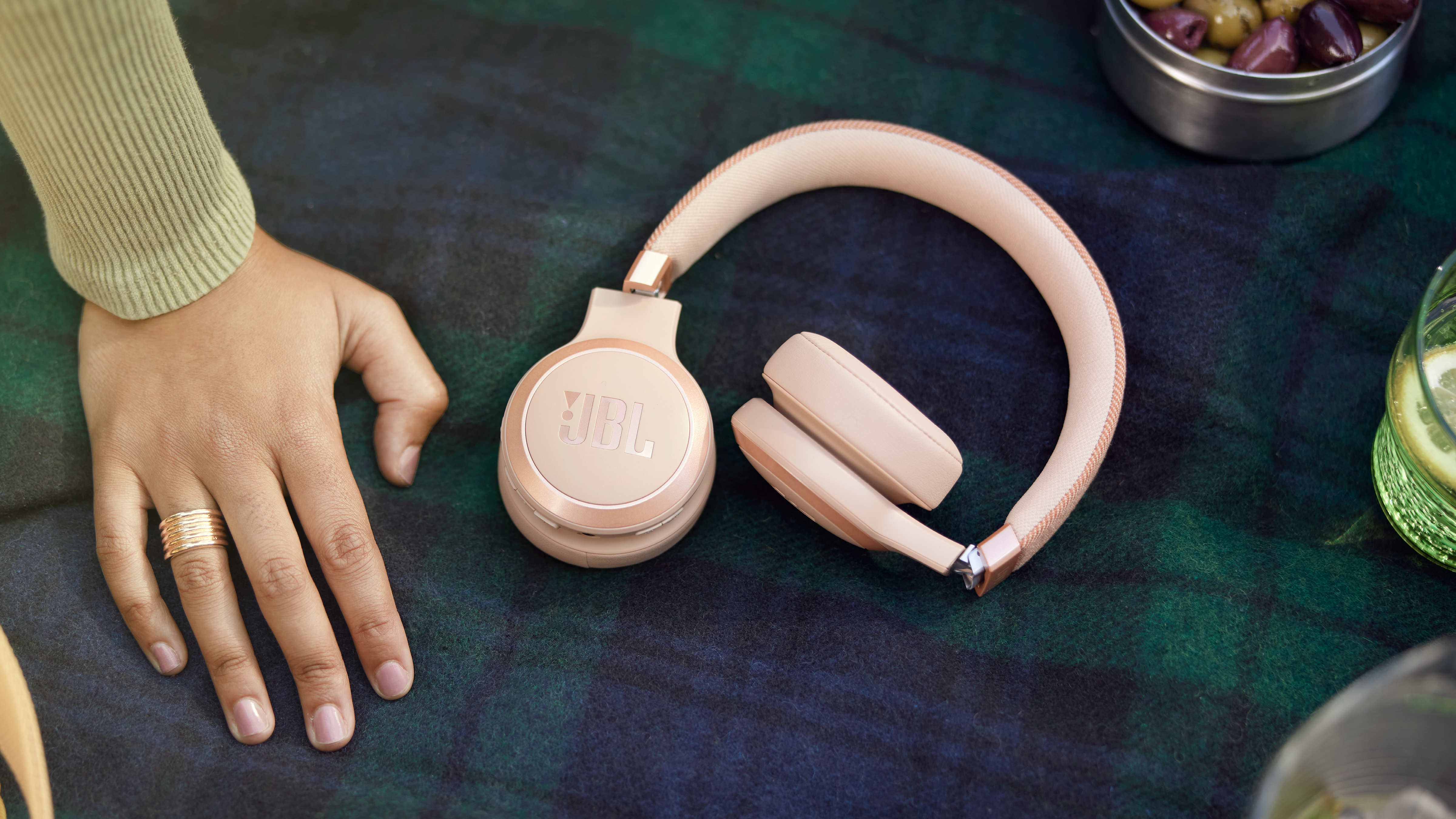 Un casque posé sur une couverture avec la main d'une personne, des bagues et d'autres objets.