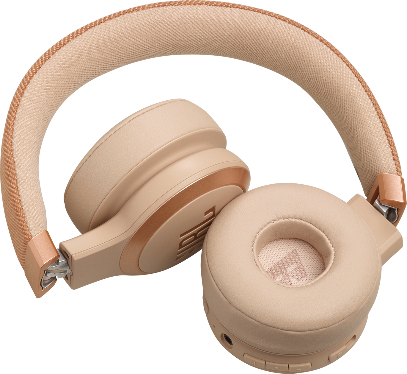 Casque beige posé sur une surface noire, avec des oreillettes visibles.