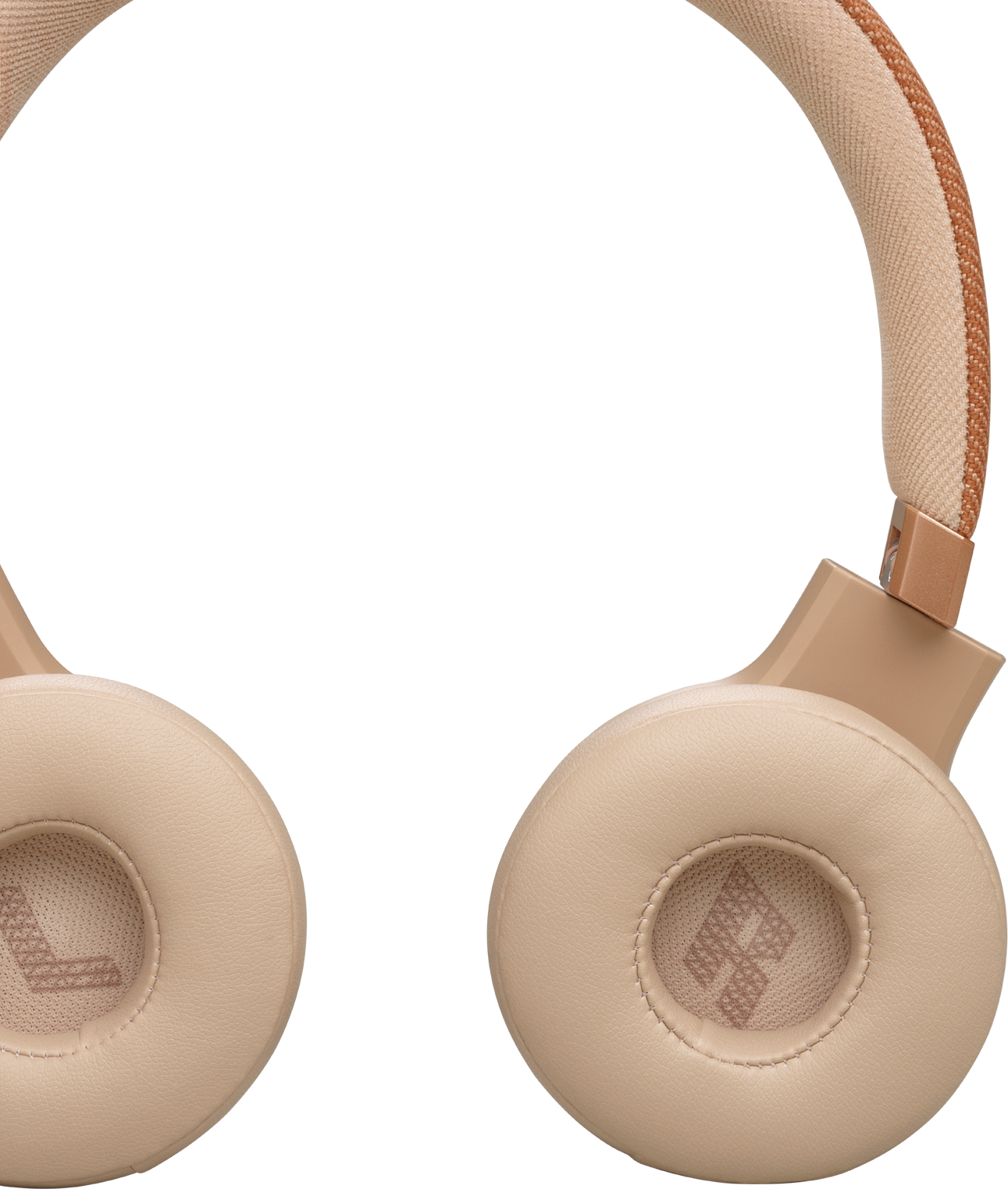 Gros plan sur un casque JBL, écouteurs et bandeau beiges, la lettre 'L' est visible.