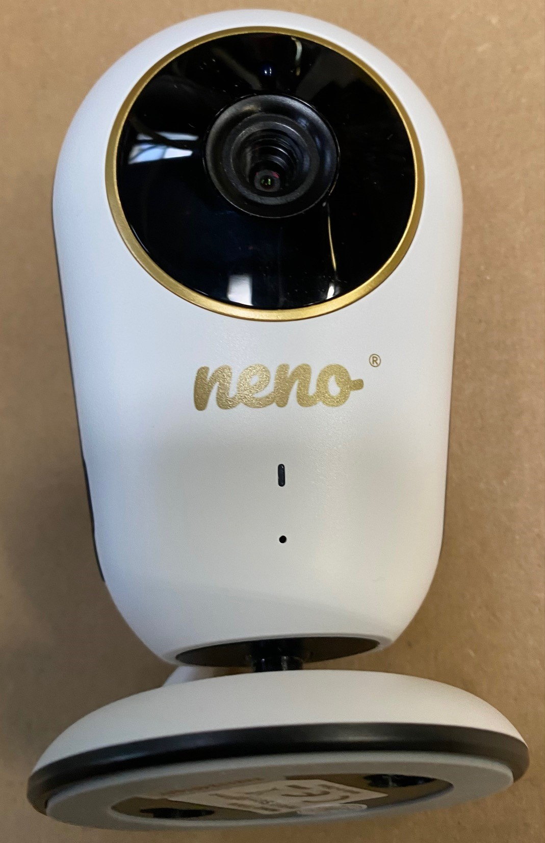 Biały niania elektroniczna ze złotym pierścieniem wokół obiektywu kamery.