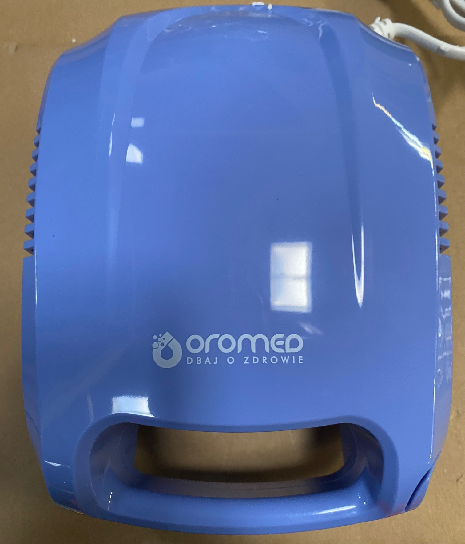 Niebieski nebulizator medyczny z marką „Oromed” i frazą „Dbaj o zdrowie” na nim.