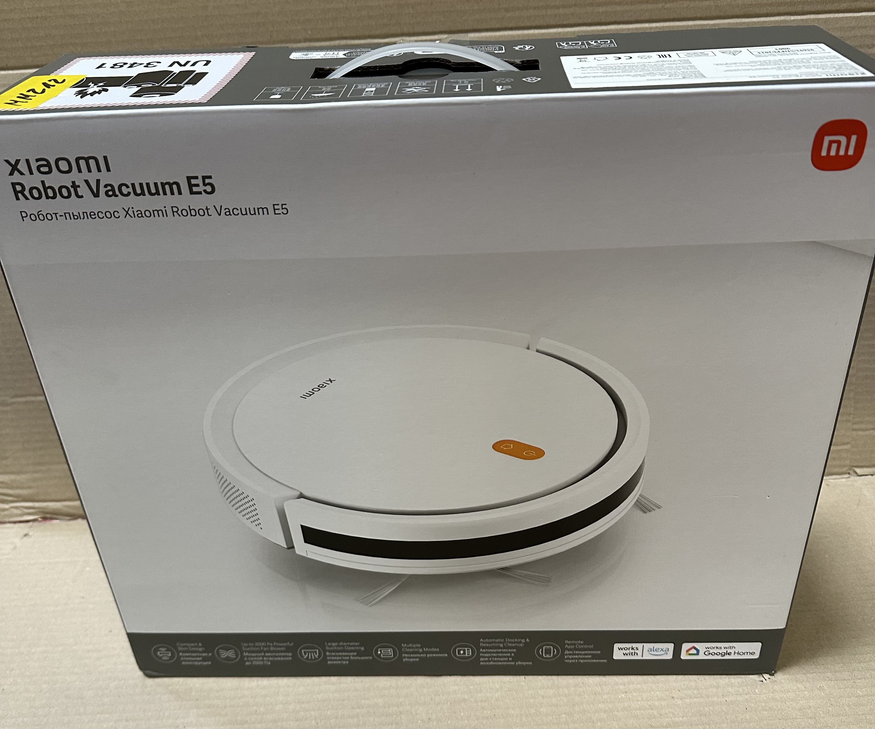 Odkurzacz robot Xiaomi w pudełku. Białe urządzenie, karton. Czarny tekst na górze.