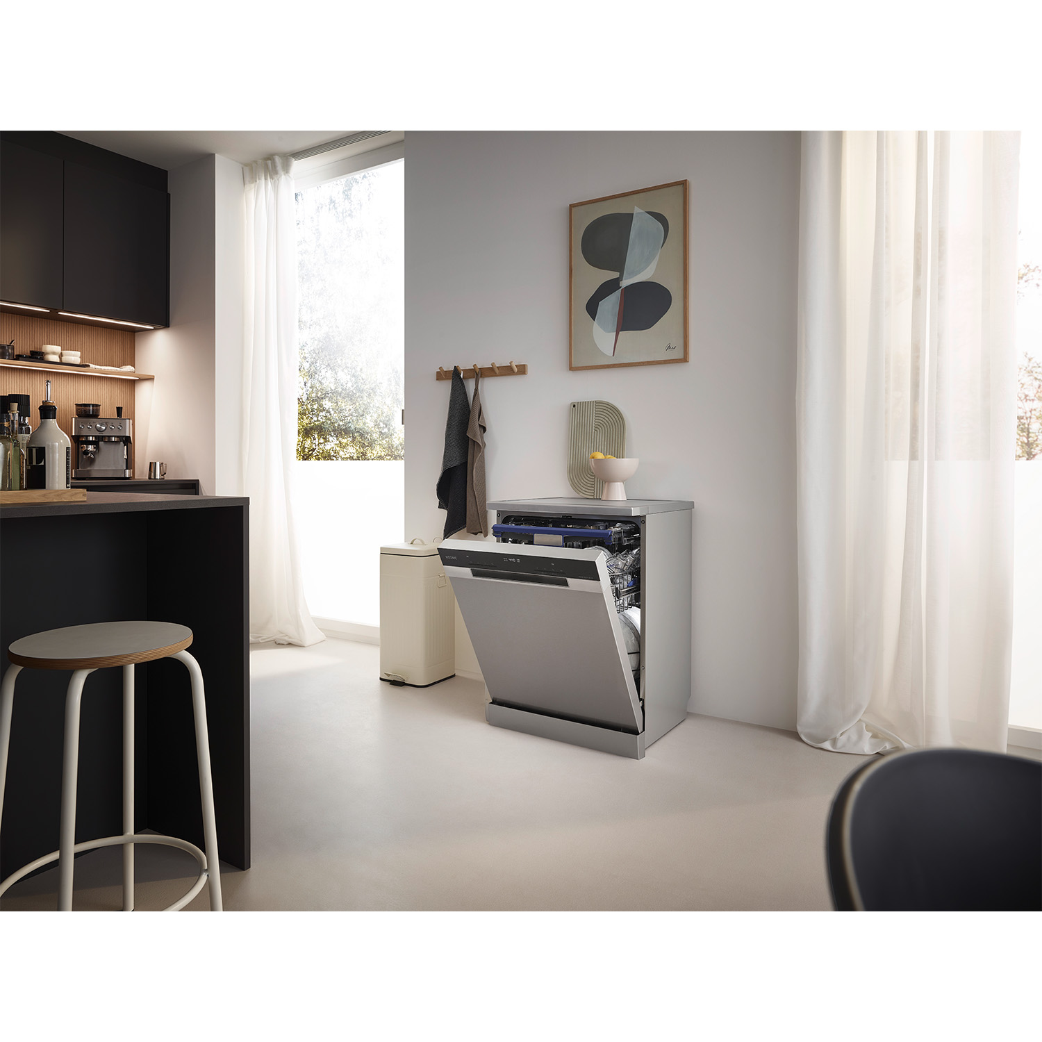 Una lavastoviglie in acciaio inossidabile con la porta aperta. Piano cucina e altri elementi visibili.