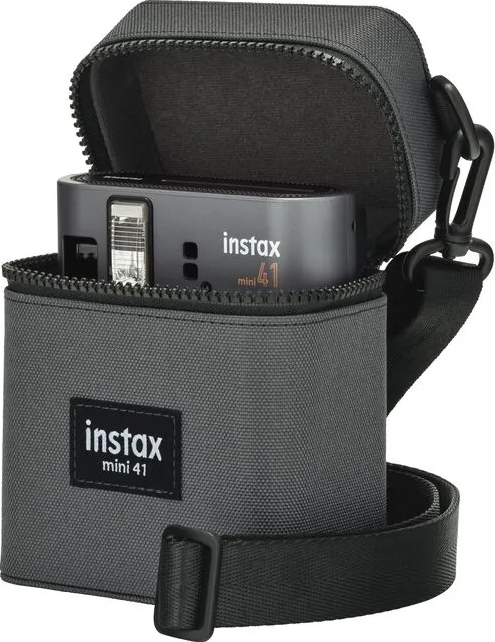 Graue Instax Mini 41 Kamera in einem grauen Etui mit schwarzem Riemen, vor weißem Hintergrund.