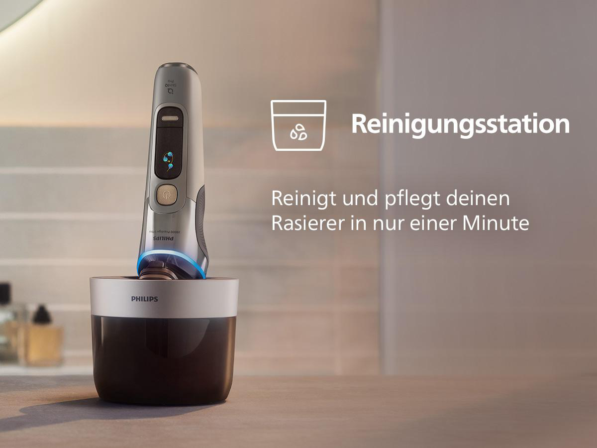 Rasierer in seiner Reinigungsstation. Die Maschine ist silbern, die Station schwarz.