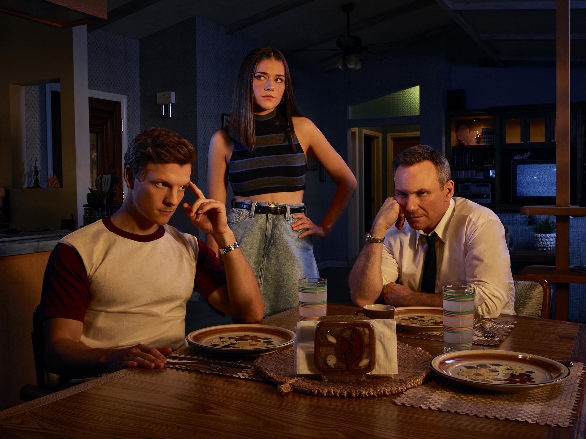 Eine Familie sitzt an einem Tisch, in einem Raum im Retro-Stil.